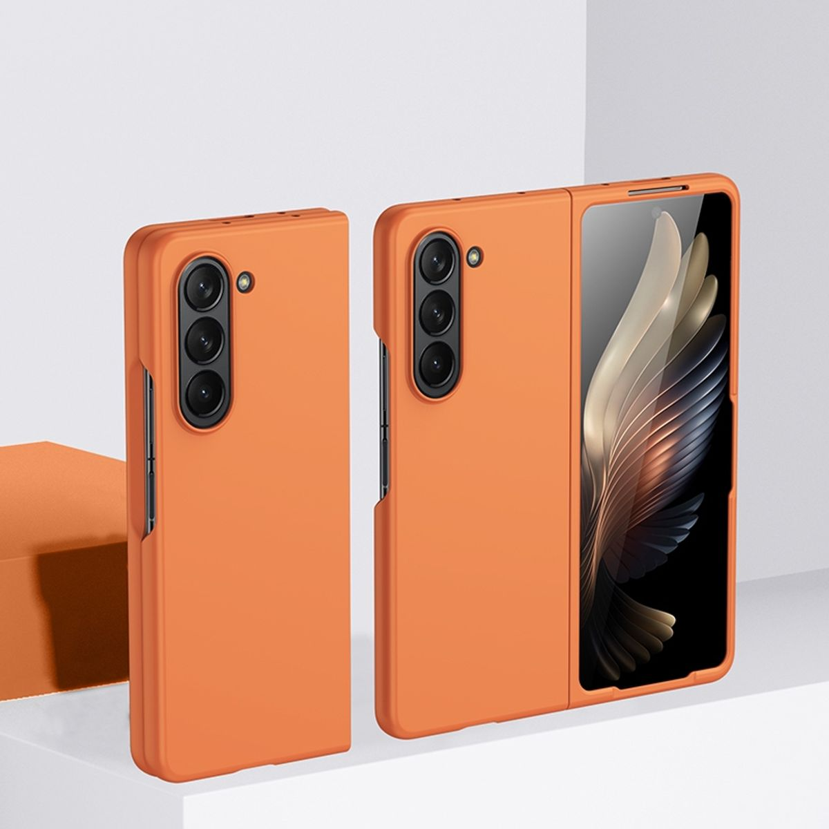 Zwei orangefarbene faltbare Telefone. Eines ist geschlossen, das andere offen und zeigt ein Bildschirmdesign.