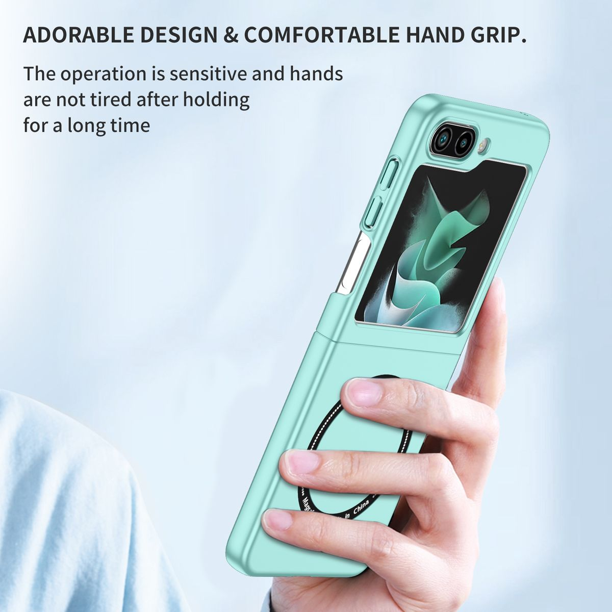 Eine türkisfarbene Handyhülle wird gehalten. Das Telefon hat einen Magnetring. Text sagt 'ADORABLE DESIGN' und 'COMFORTABLE HAND GRIP'.