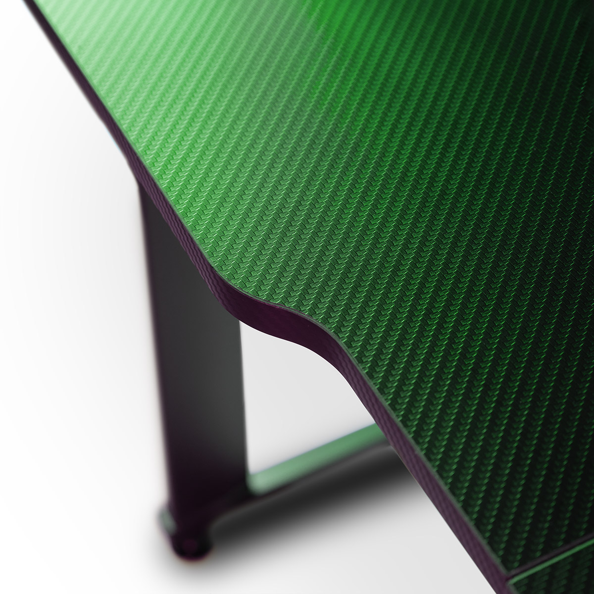 Primer plano de una textura de fibra de carbono verde en el borde de un escritorio.
