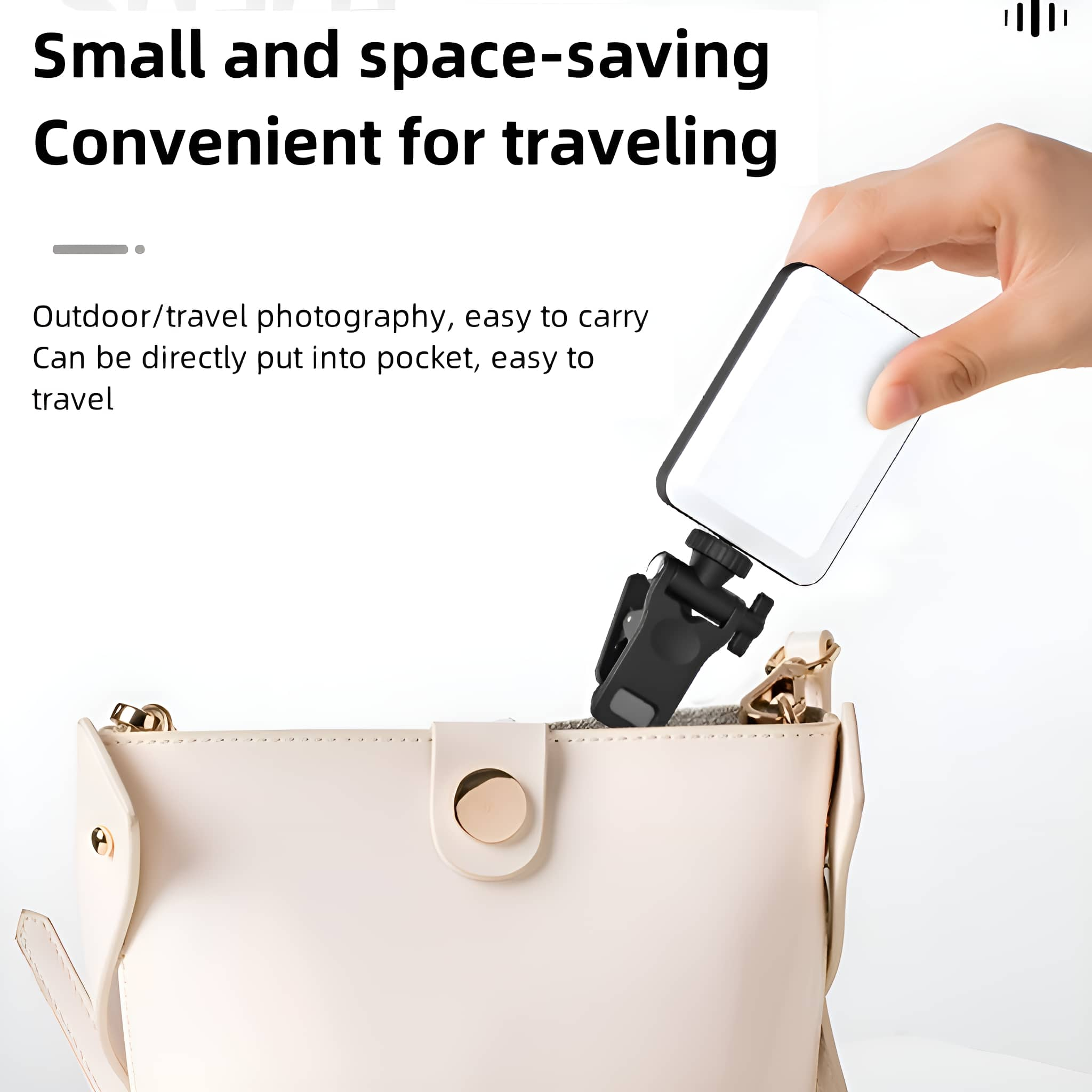 Eine Hand, die ein weißes und schwarzes Reisezubehör über einer beigen Handtasche hält.