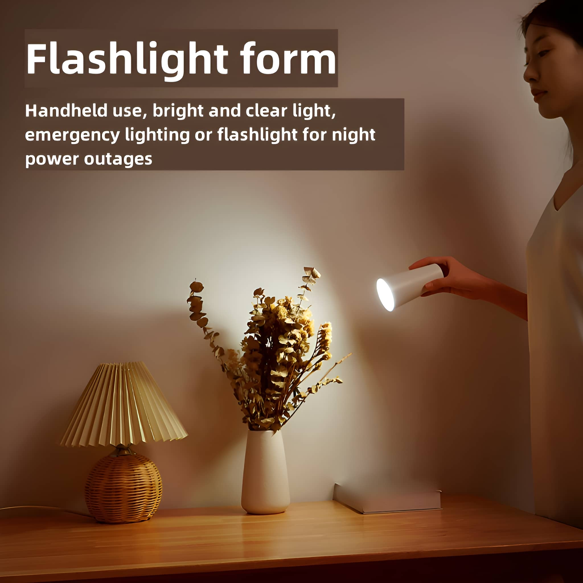 Frau hält weiße Taschenlampe. Beige Wand, Tisch mit Lampe, Vase mit Trockenblumen.