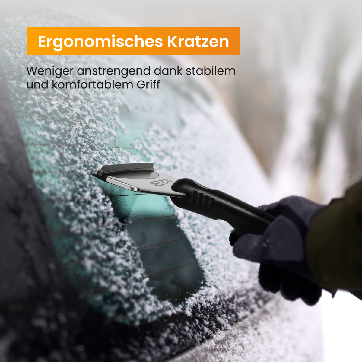 Een hand die een zwarte ijskrabber gebruikt op een autoruit met sneeuw.