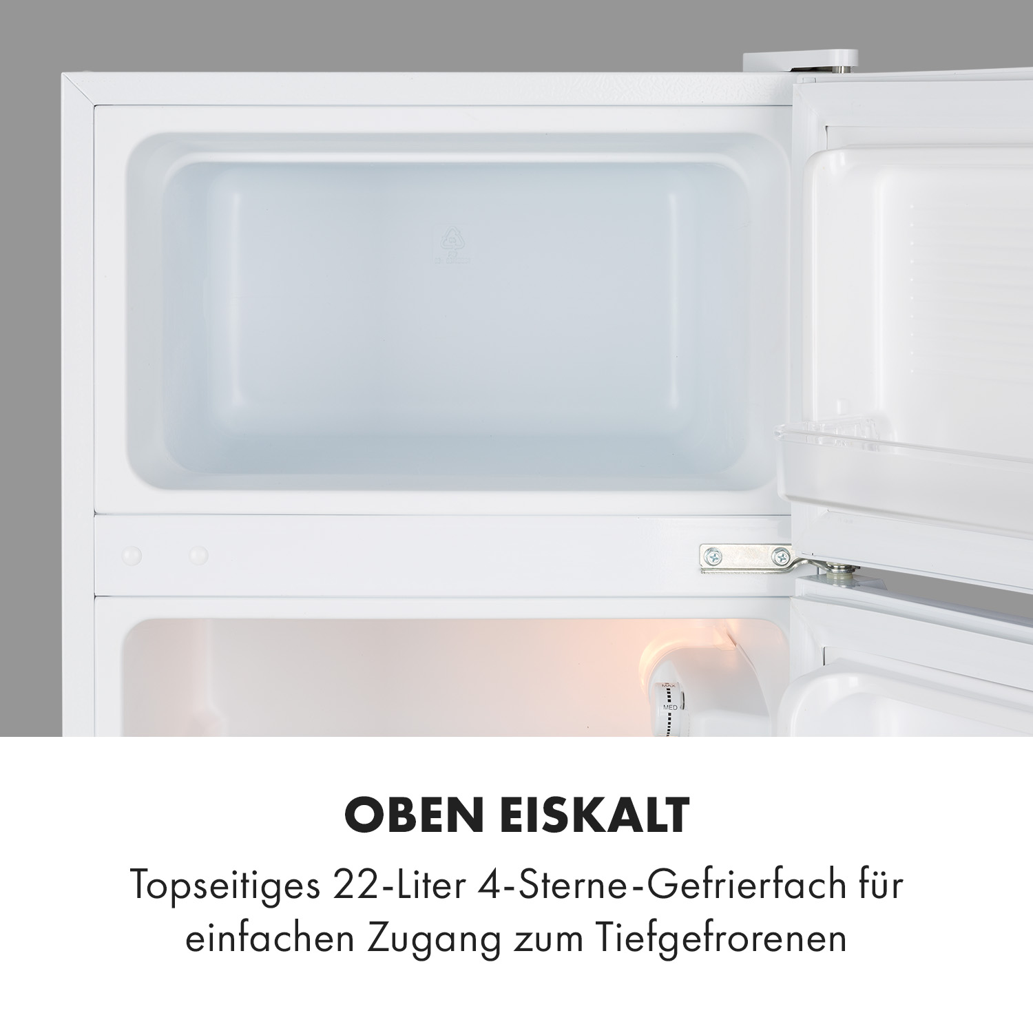 Interno frigorifero bianco. La porta aperta rivela l'interno. Il testo dice 'OBEN EISKALT'.