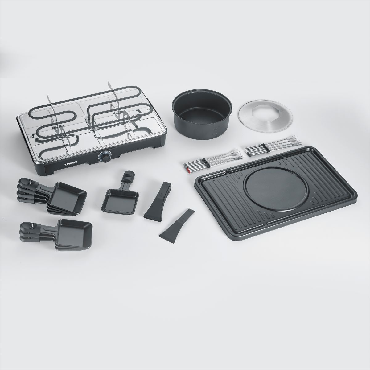 Zestaw do grillowania raclette z różnymi komponentami. Zawiera grill, patelnie, szpatułki i akcesoria.