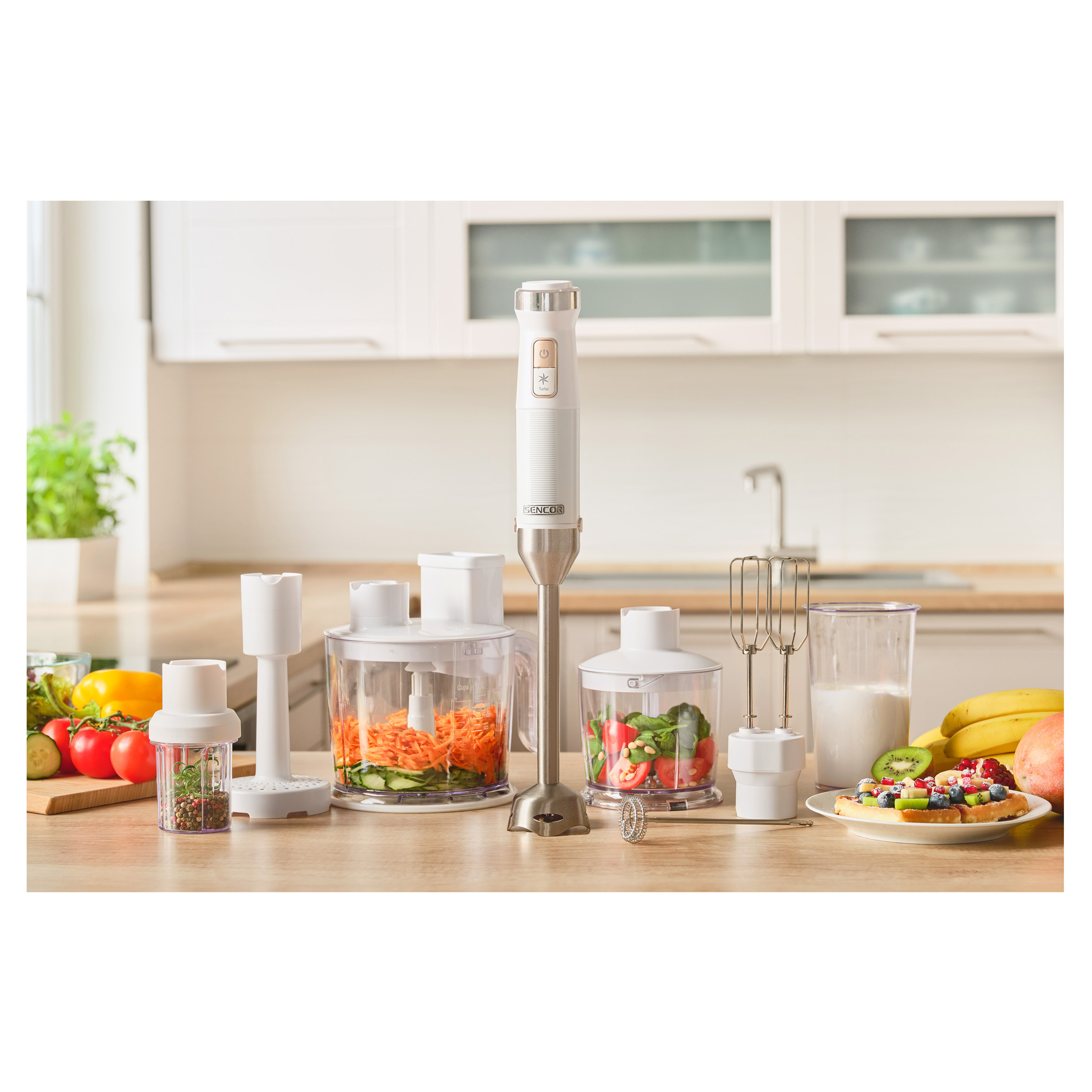 Assortimento di elettrodomestici da cucina bianchi e ingredienti su tavolo.