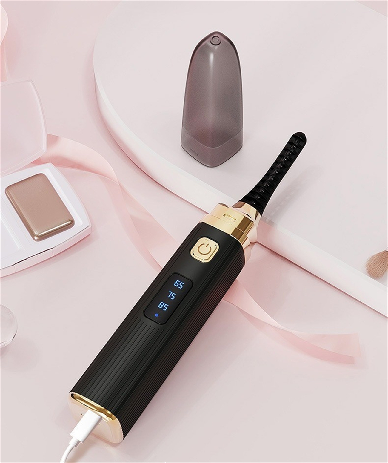 Schwarzer und goldener Wimpernformer mit LCD-Bildschirm und Ladeanschluss.