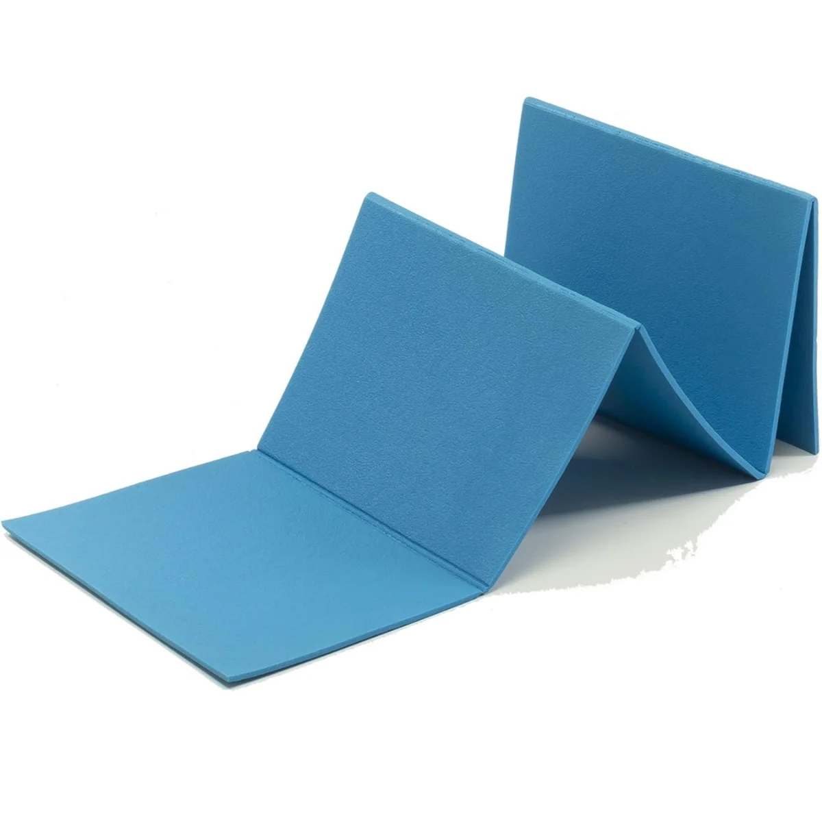 A blue foldable mat, partially folded, lying on a white surface.