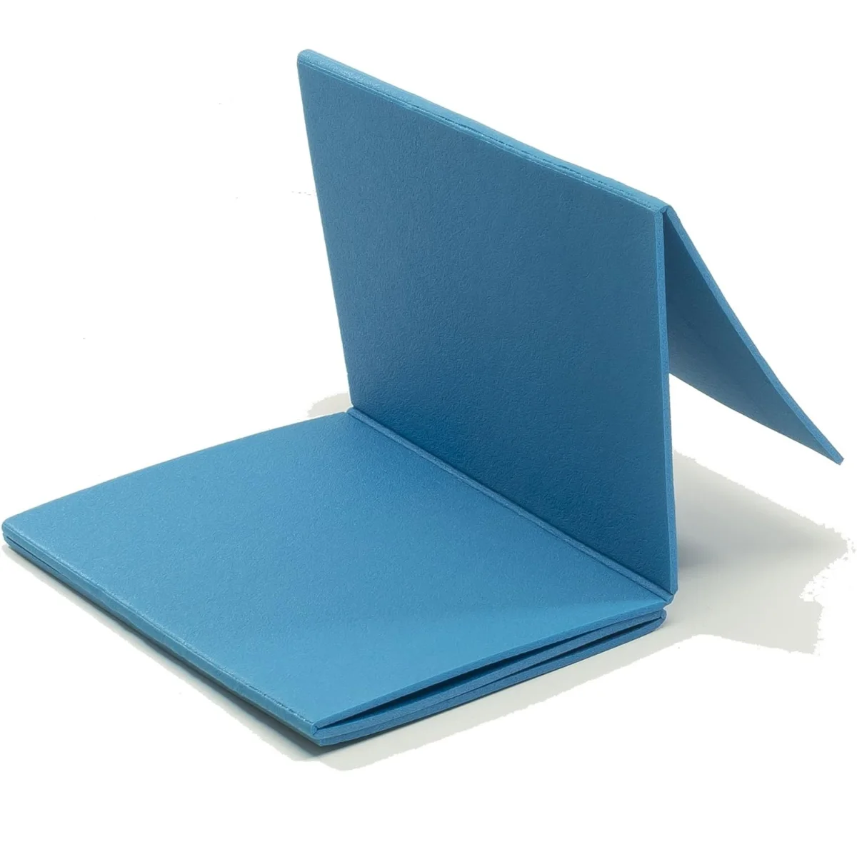 A folded blue notebook. The notebook is open, standing on a white surface.