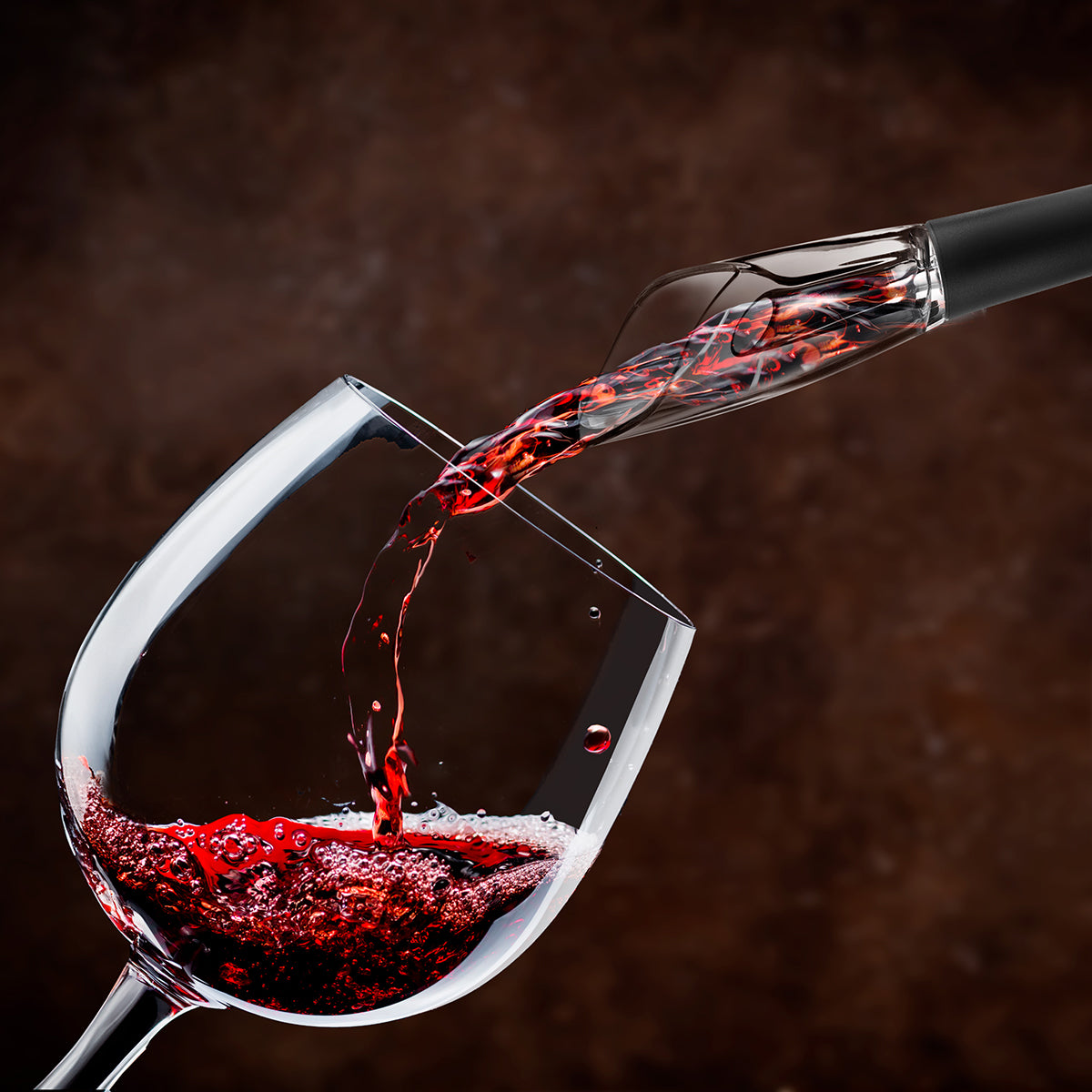 Vino rosso versato in un bicchiere da un aeratore per vino.