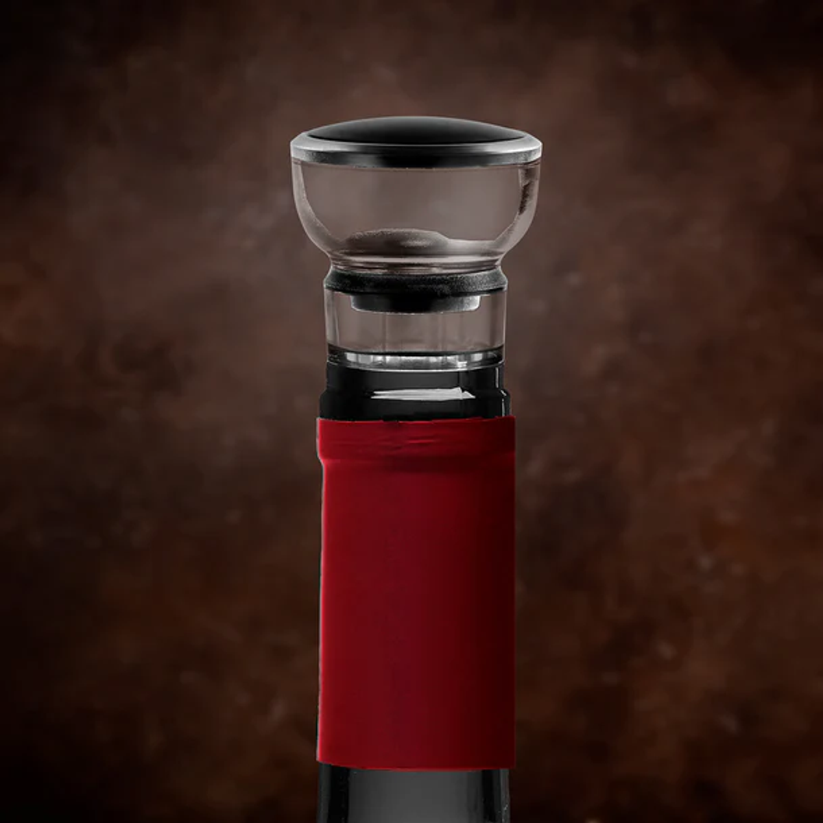 Aeratore per vino su una bottiglia di vino. L'aeratore è trasparente e la bottiglia ha un sigillo rosso.