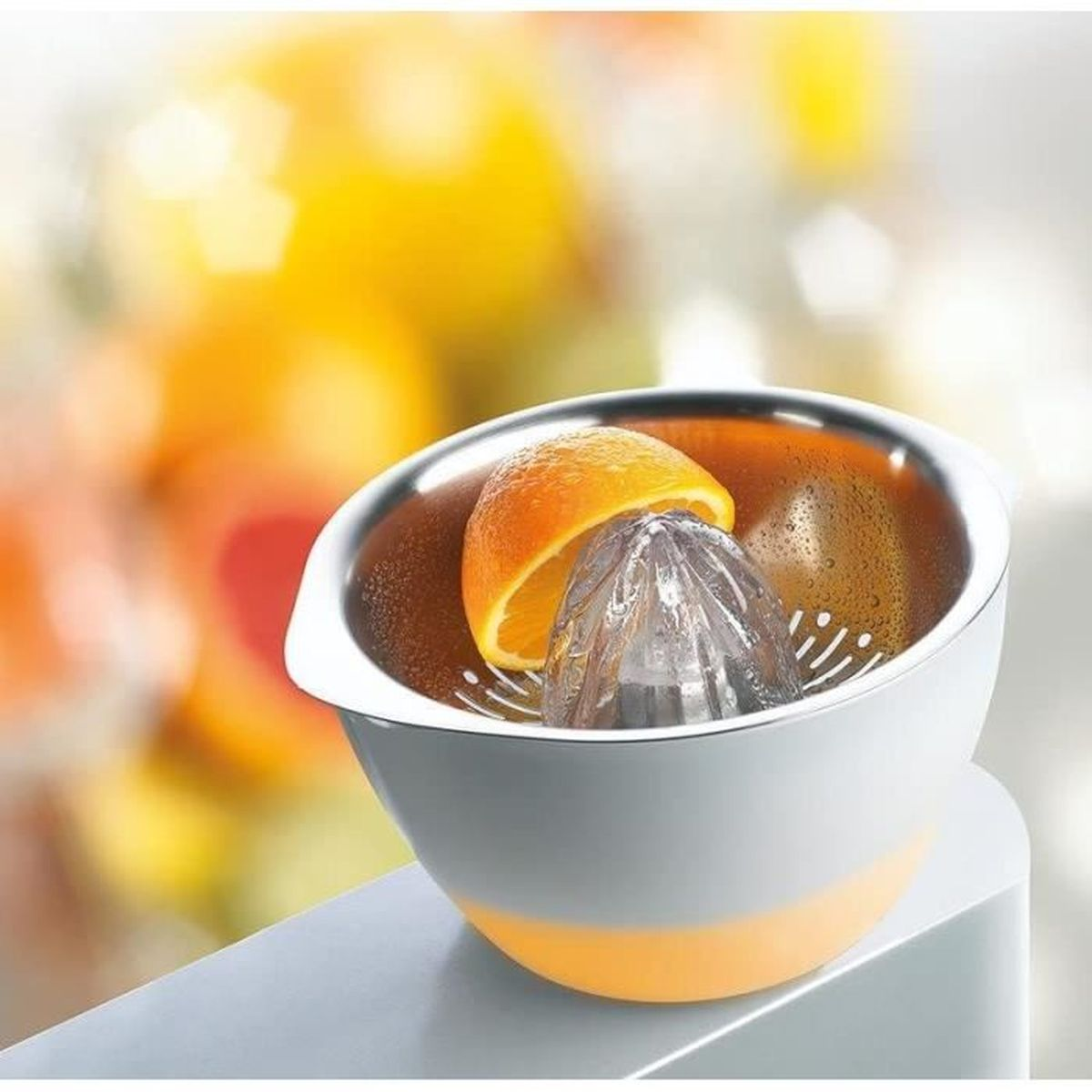 Połówka pomarańczy na wyciskarce do cytrusów, z przezroczystym stożkiem w białej misce.