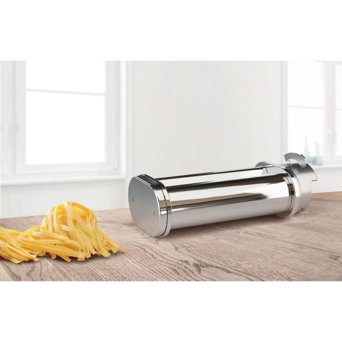 Máquina para hacer pasta y pasta fresca sobre una superficie de madera.