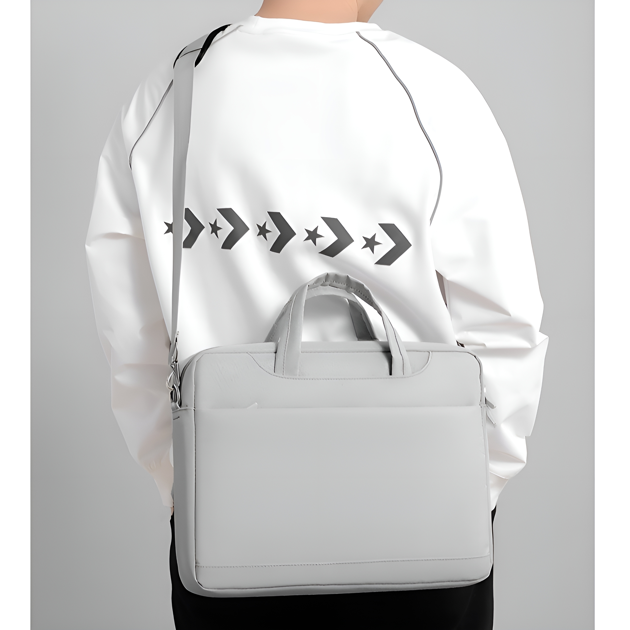Person trägt eine weiße Jacke mit einer grauen Laptoptasche. Die Tasche ist hellgrau, mit Griff und Riemen.