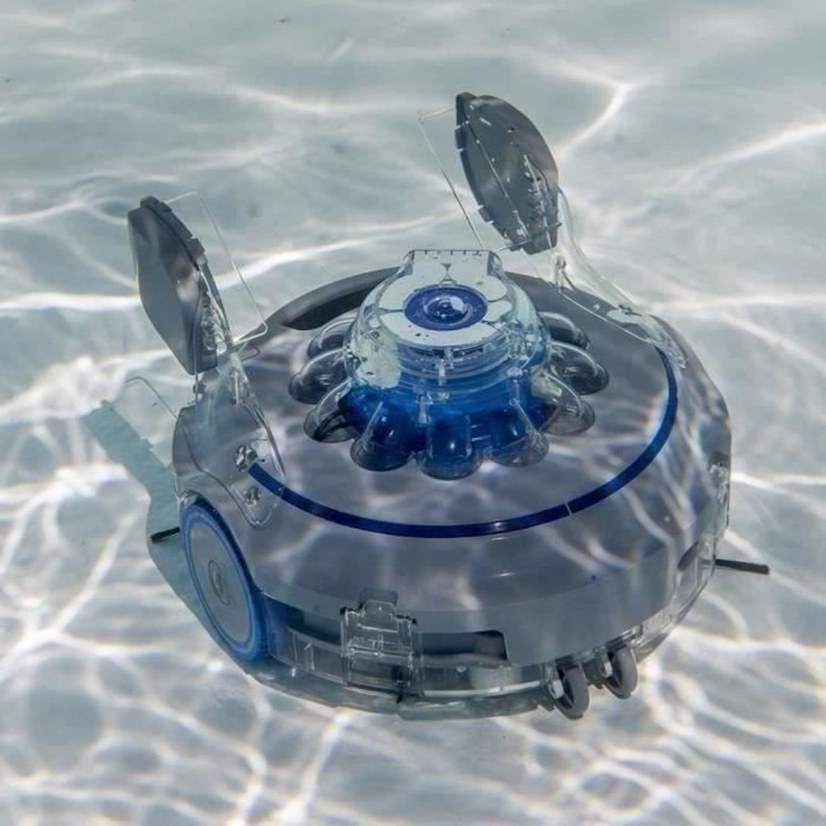 Una aspiradora robot gris y azul en agua clara. Tiene tapas y aletas laterales de plástico transparente.