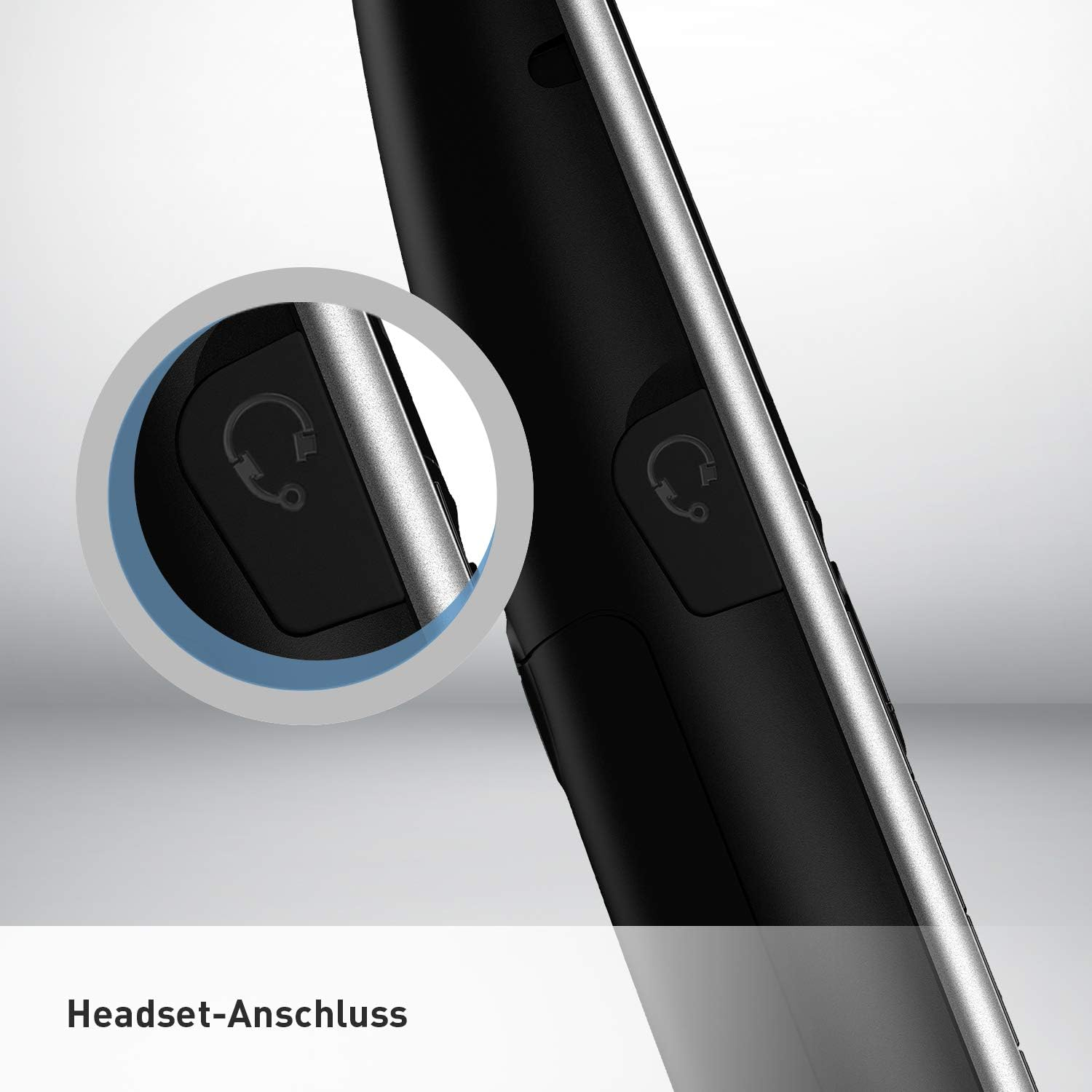 Gros plan d'un téléphone noir avec une prise casque, encerclé. Fond blanc.