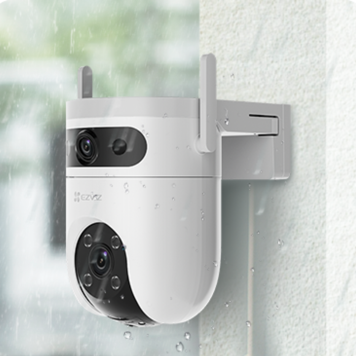 Biała kamera monitoringu z kroplami deszczu, zamontowana na ścianie.