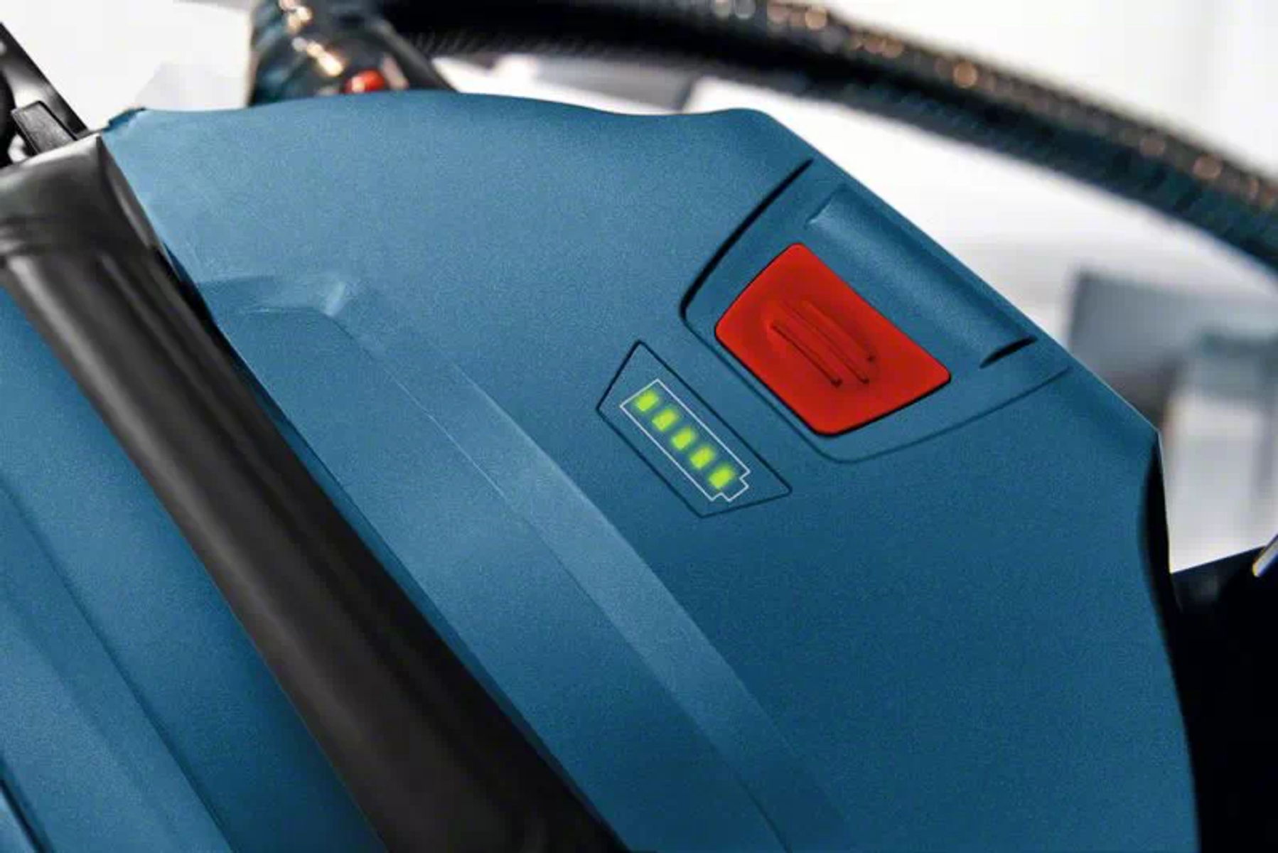 Primo piano di un elettroutensile blu con pulsante rosso e luci.