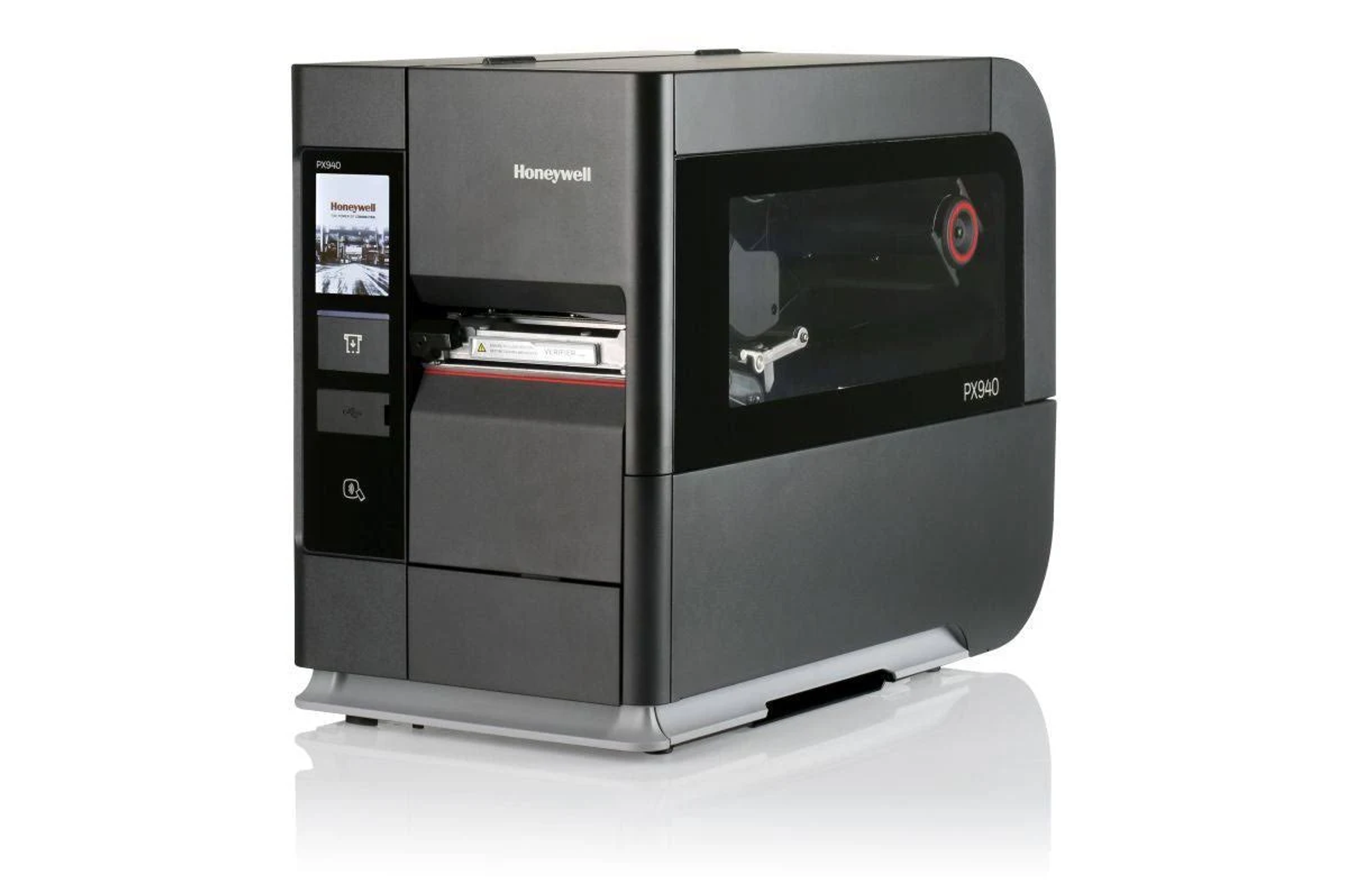 Ein dunkelgrauer Honeywell-Drucker auf weißer Oberfläche. Der Drucker hat einen Bildschirm und einen sichtbaren Etikettenschlitz.
