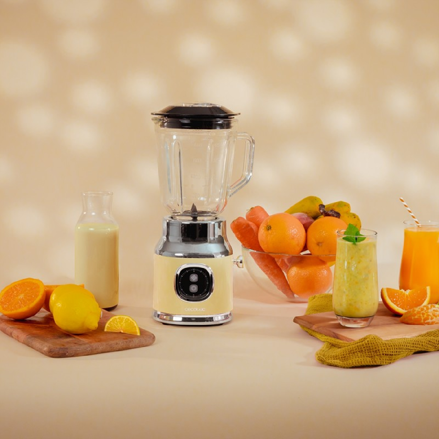 Una licuadora con base beige, con frutas, jugo e ingredientes sobre una mesa.