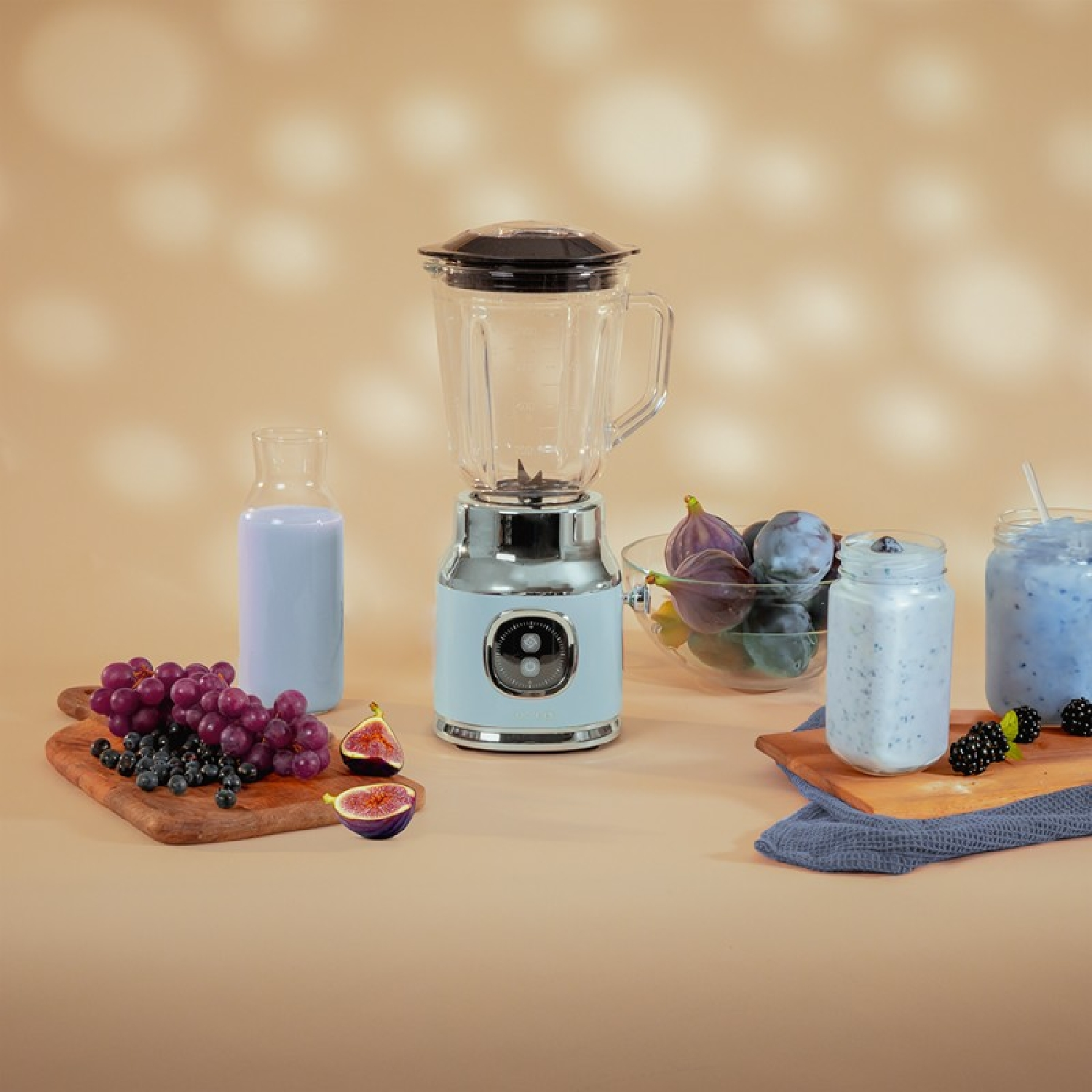 Licuadora, fruta y bebidas en una mesa. Fondo marrón claro.
