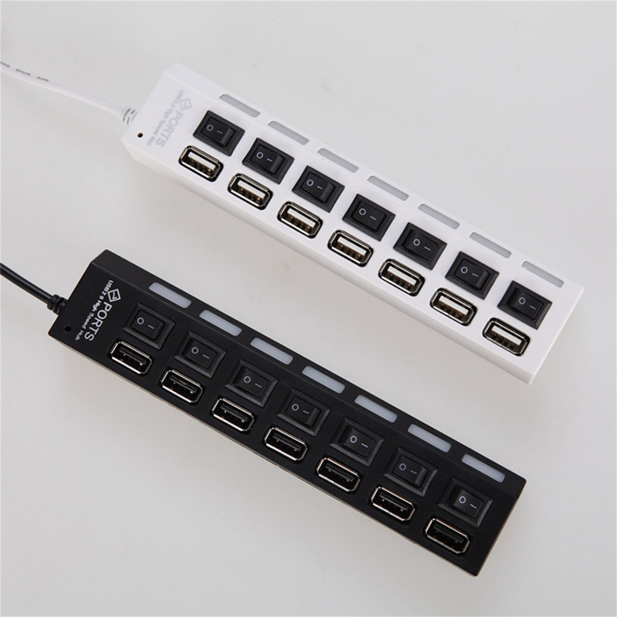 Zwei USB-Hubs, einer weiß und einer schwarz, mit mehreren USB-Anschlüssen und Schaltern.