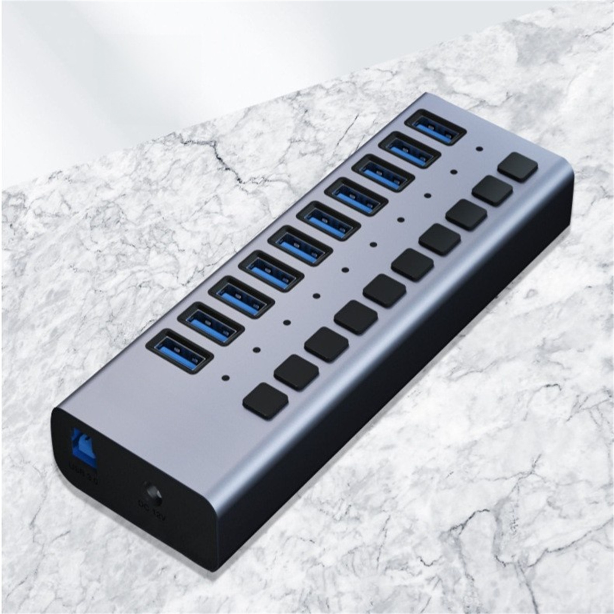 Silberner USB-Hub mit mehreren blauen USB-Anschlüssen und schwarzen Power-Buttons auf Marmoroberfläche.