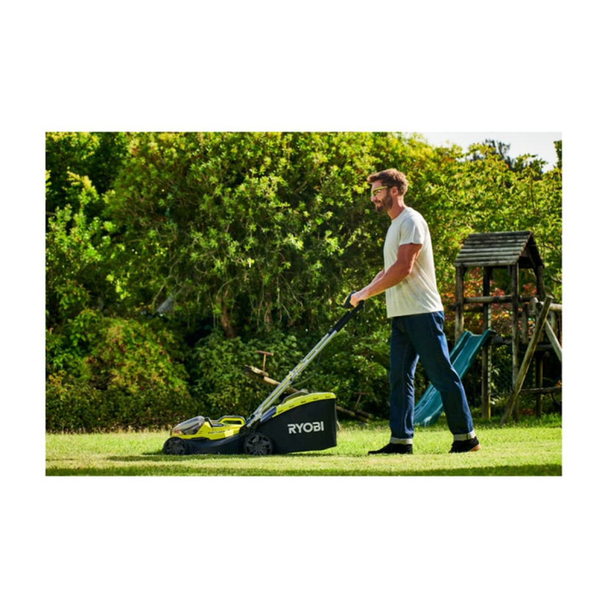 Ein Mann mäht den Rasen mit einem grün-schwarzen RYOBI-Rasenmäher. Grünes Gras und Bäume im Hintergrund.