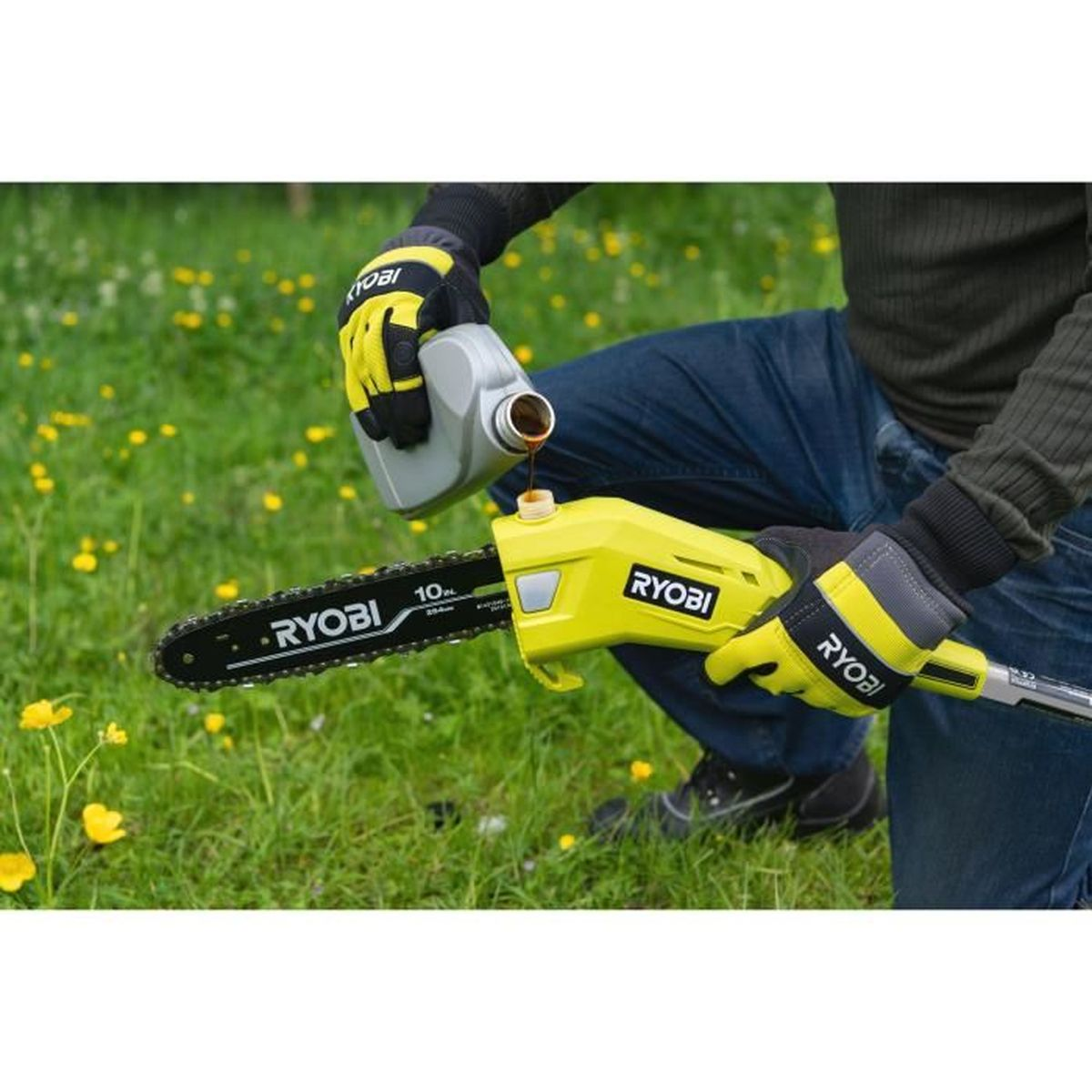Person gießt Öl in eine gelbe Kettensäge im Gras mit Blumen.