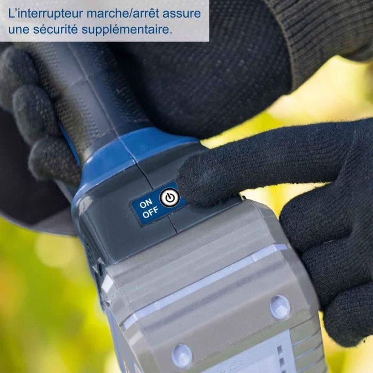 Die Hand drückt auf einen Ein/Aus-Knopf eines schwarz-grauen Geräts mit Handschuhen, grüner Hintergrund.