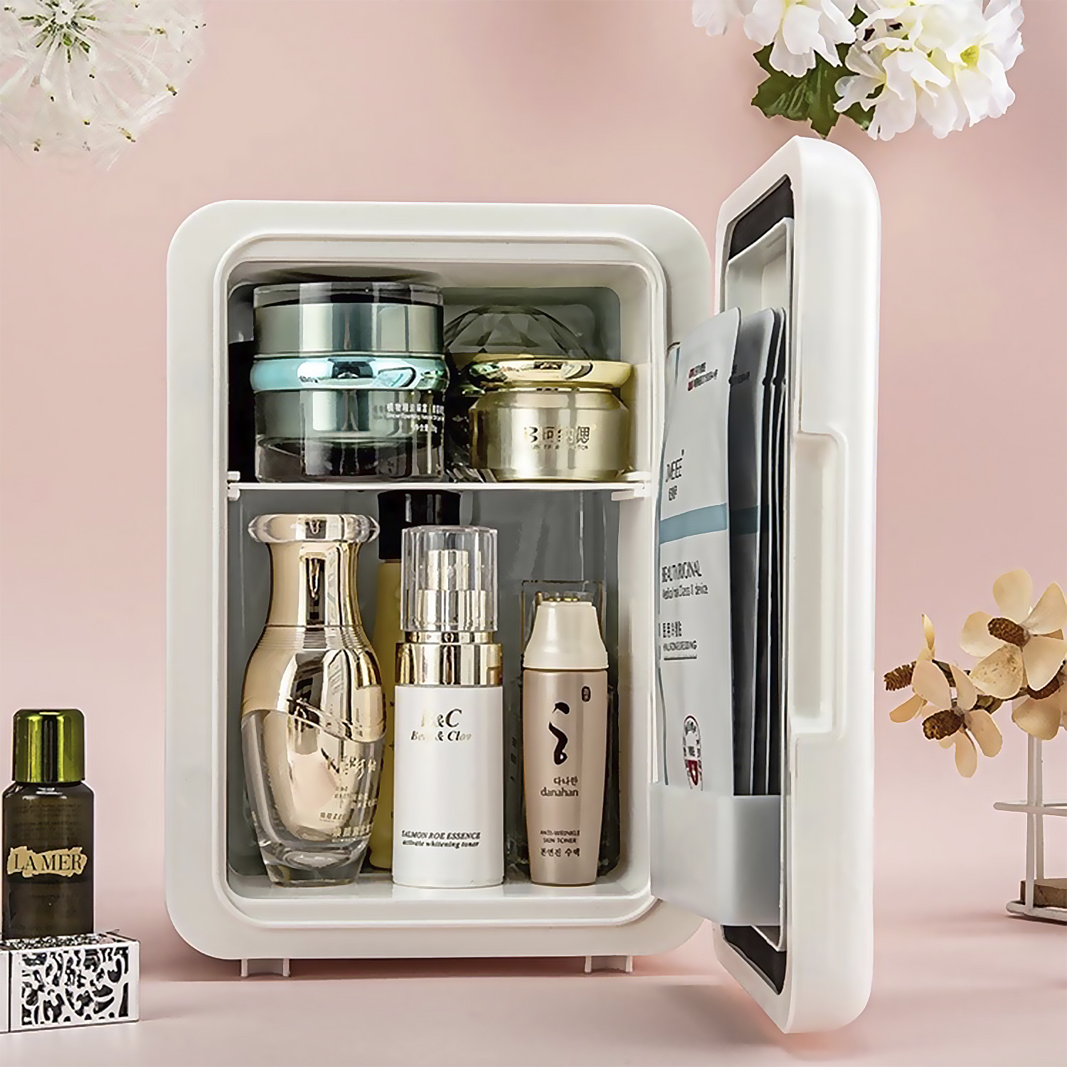 Un mini-frigo bianco pieno di prodotti per la cura della pelle. Una piccola bottiglia di profumo è fuori.
