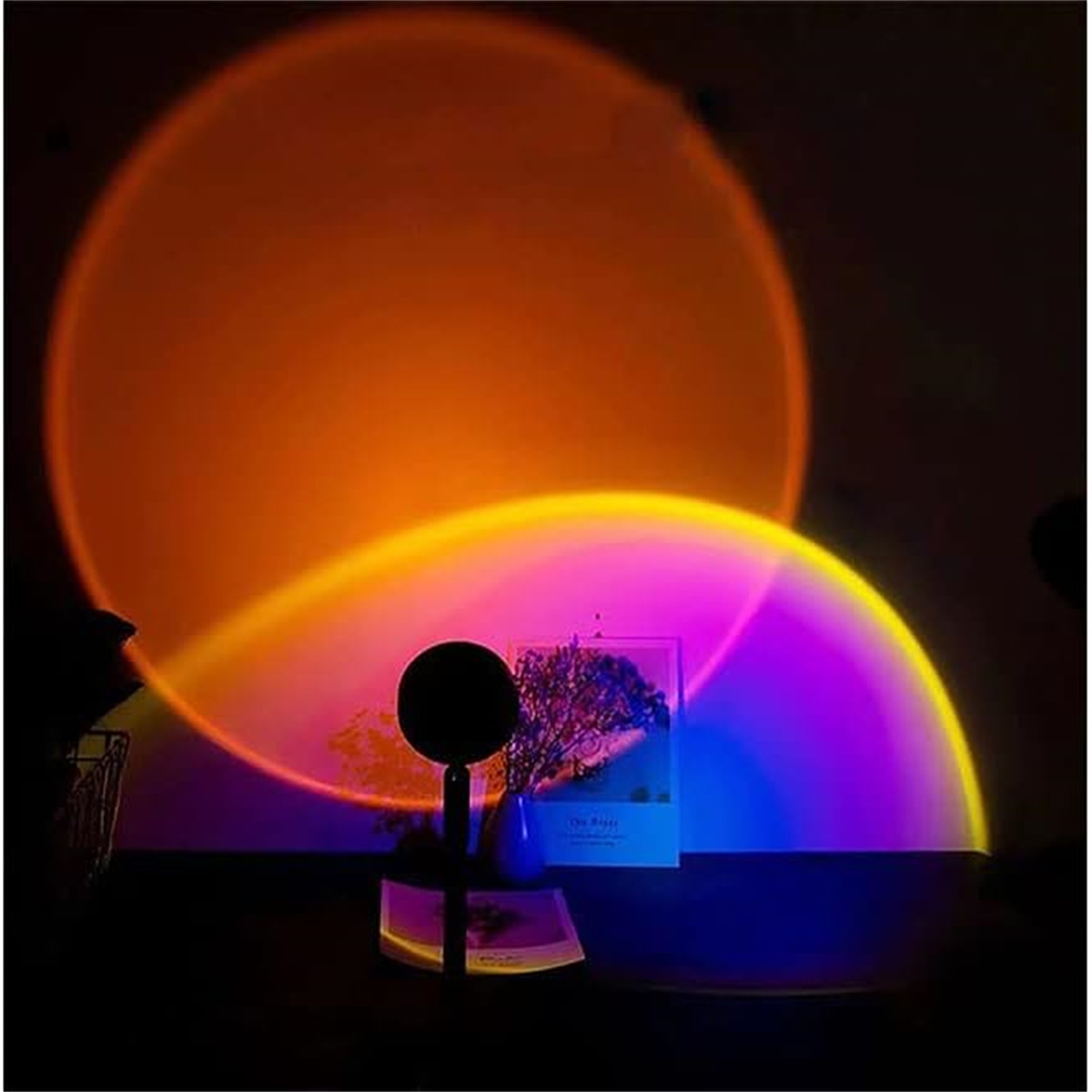 Sonnenuntergangslampe, die orange und violette Lichtkreise auf dunkler Oberfläche projiziert.
