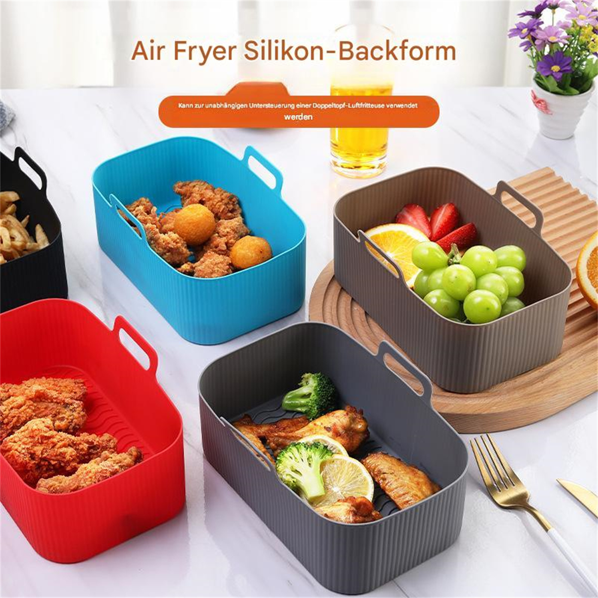 Vier Silikon-Airfryer-Körbe mit Essen: Pommes, gebratenes Huhn, Trauben und Brokkoli.
