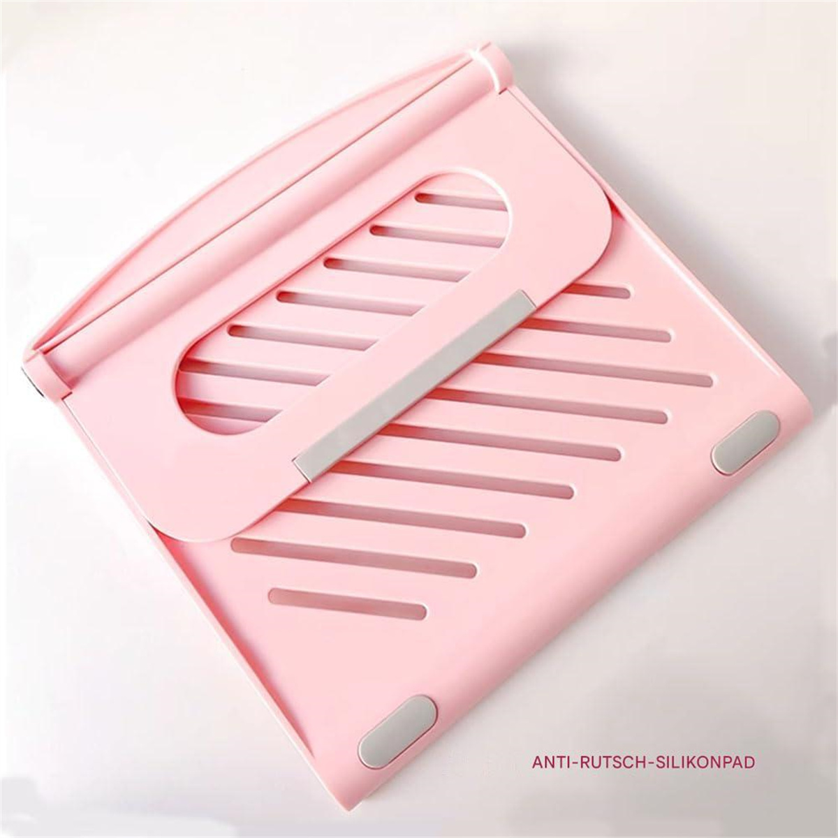Ein rosa Laptop-Ständer, zusammengeklappt, mit einem grauen Griff in der Mitte, auf einer weißen Oberfläche.