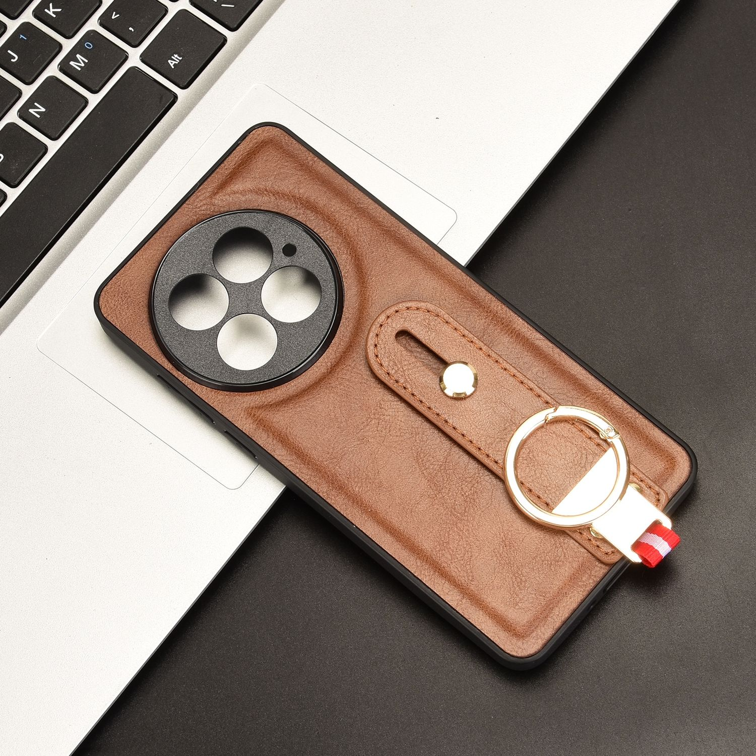 Funda de teléfono de cuero marrón con recorte de cámara circular, soporte de anillo metálico y borde negro.