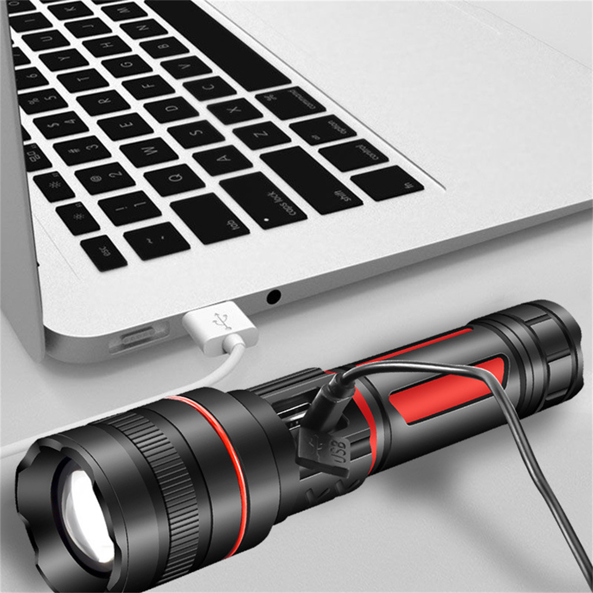 Schwarze und rote Taschenlampe, über USB mit einem Laptop verbunden. USB-Kabel ist weiß.