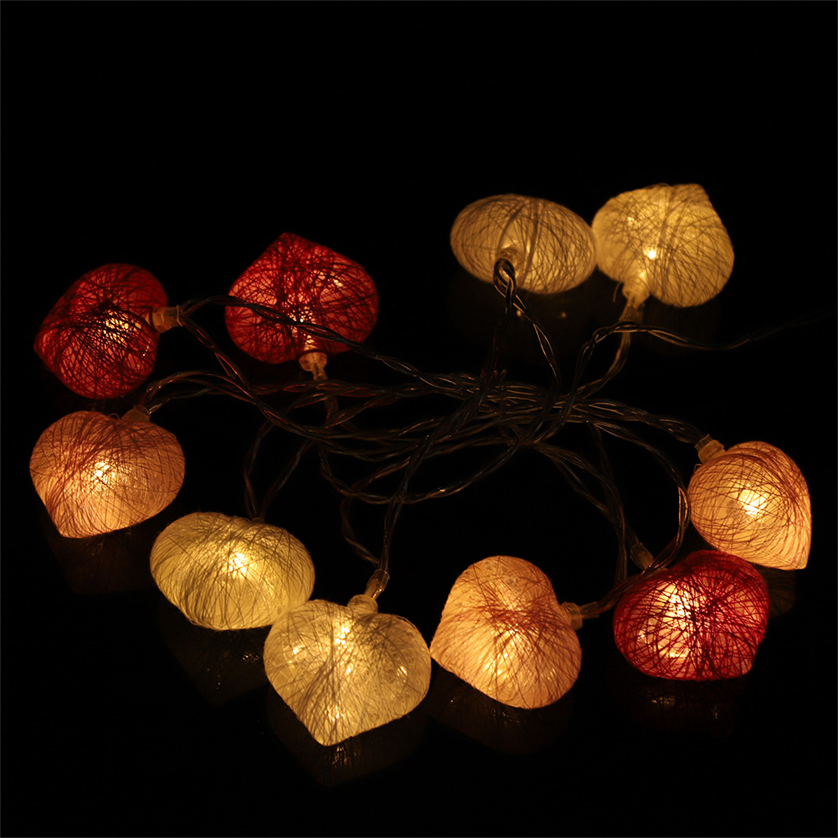 Herzförmige Lichterketten. Rote und weiße Lichter auf schwarzem Hintergrund.