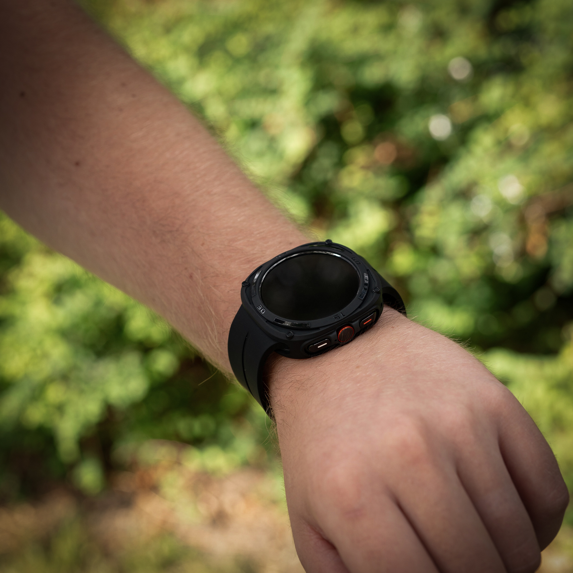 Handgelenk eines Mannes mit schwarzer Smartwatch. Die Uhr hat ein schwarzes Armband.