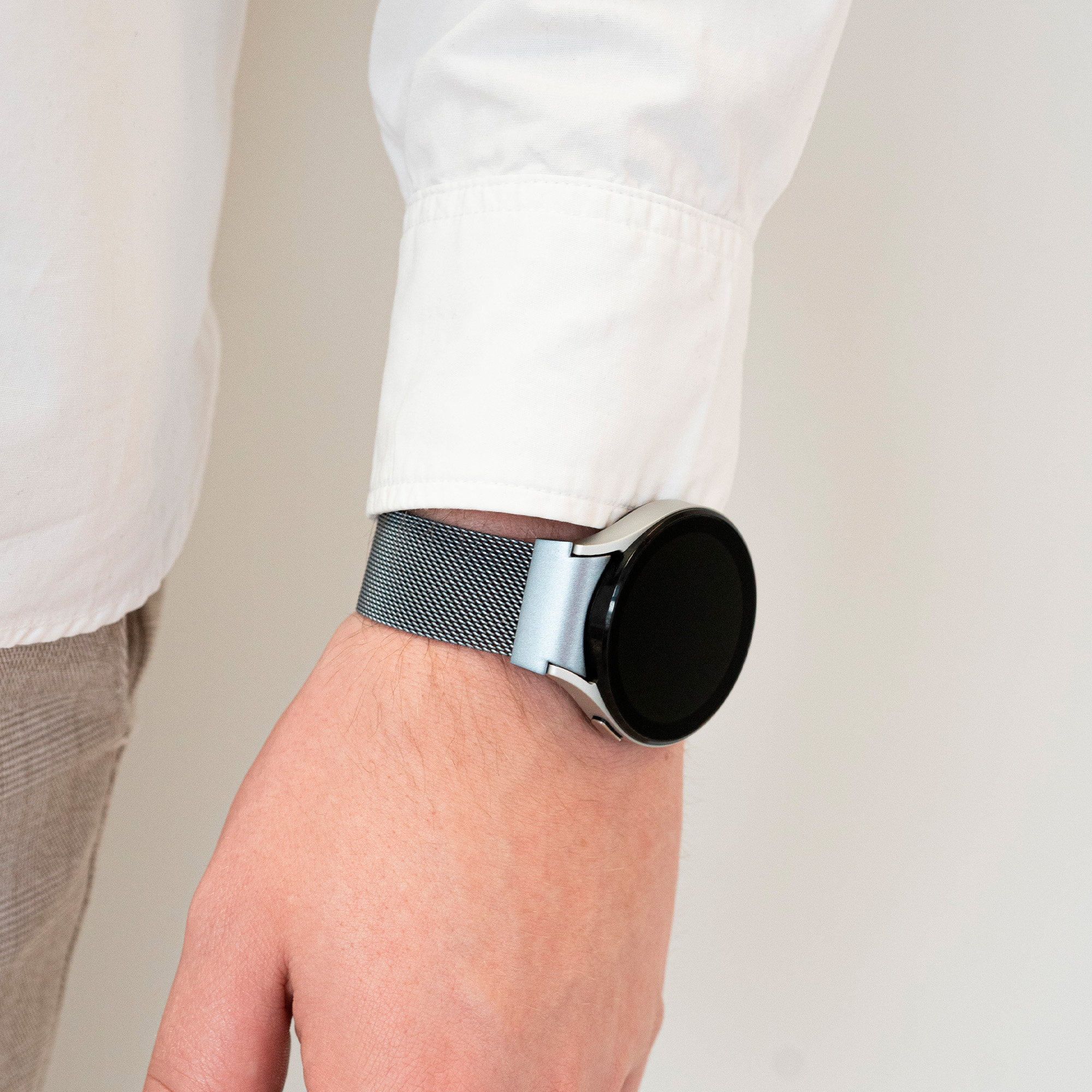 Mann trägt eine schwarze Smartwatch mit silbernem Armband. Die Uhr ist an seinem linken Handgelenk.