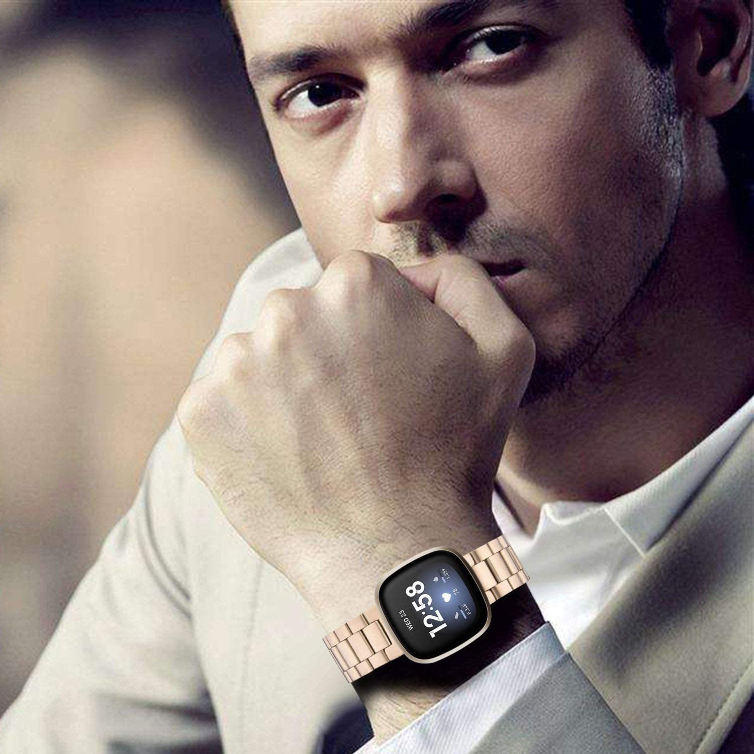 Ein Mann trägt eine Uhr mit Metallarmband, die Uhr zeigt eine digitale Oberfläche.