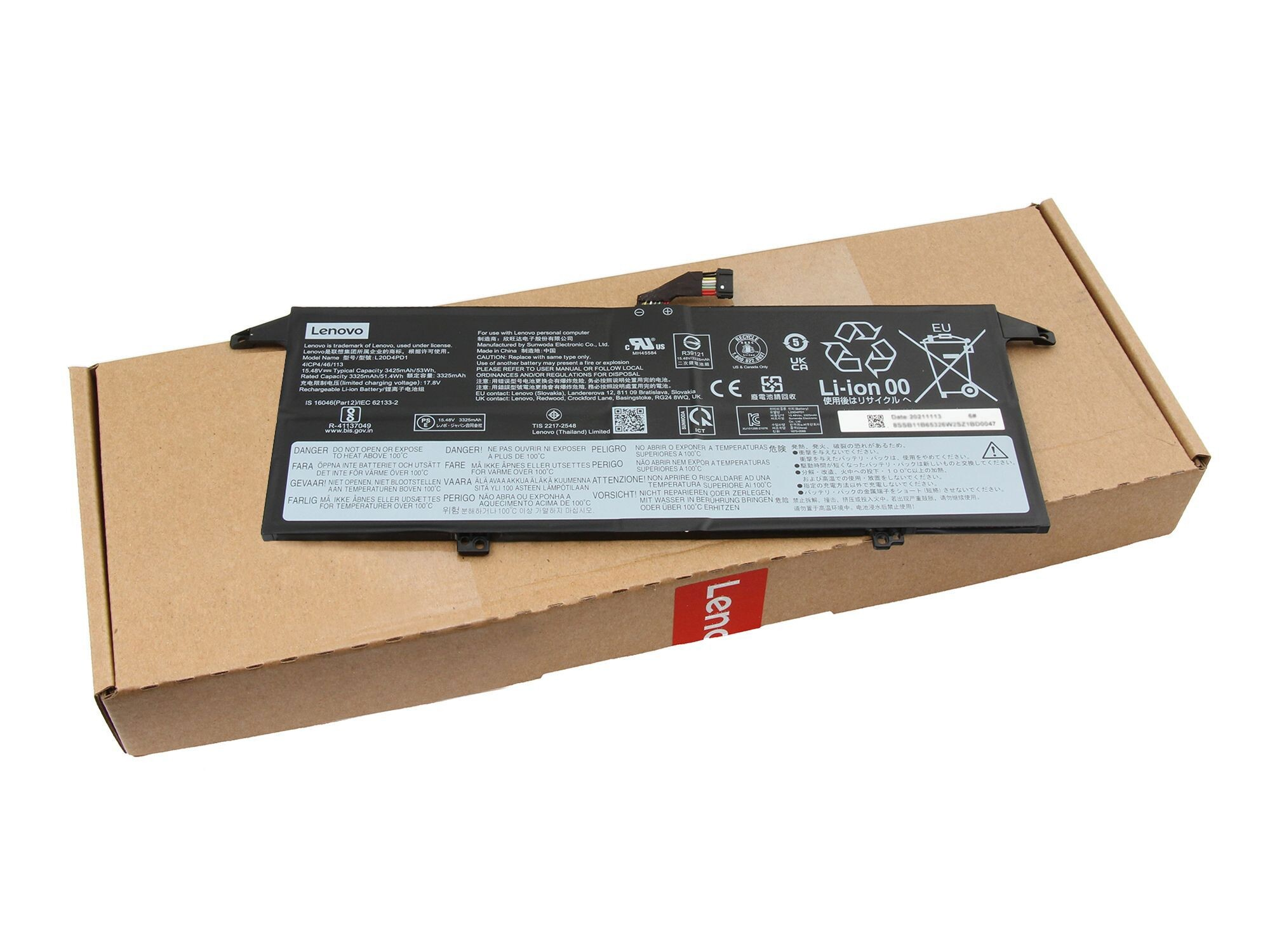 Laptop-Akku auf einem Karton. Akku schwarz mit Etiketten; Karton braun mit rotem Logo.