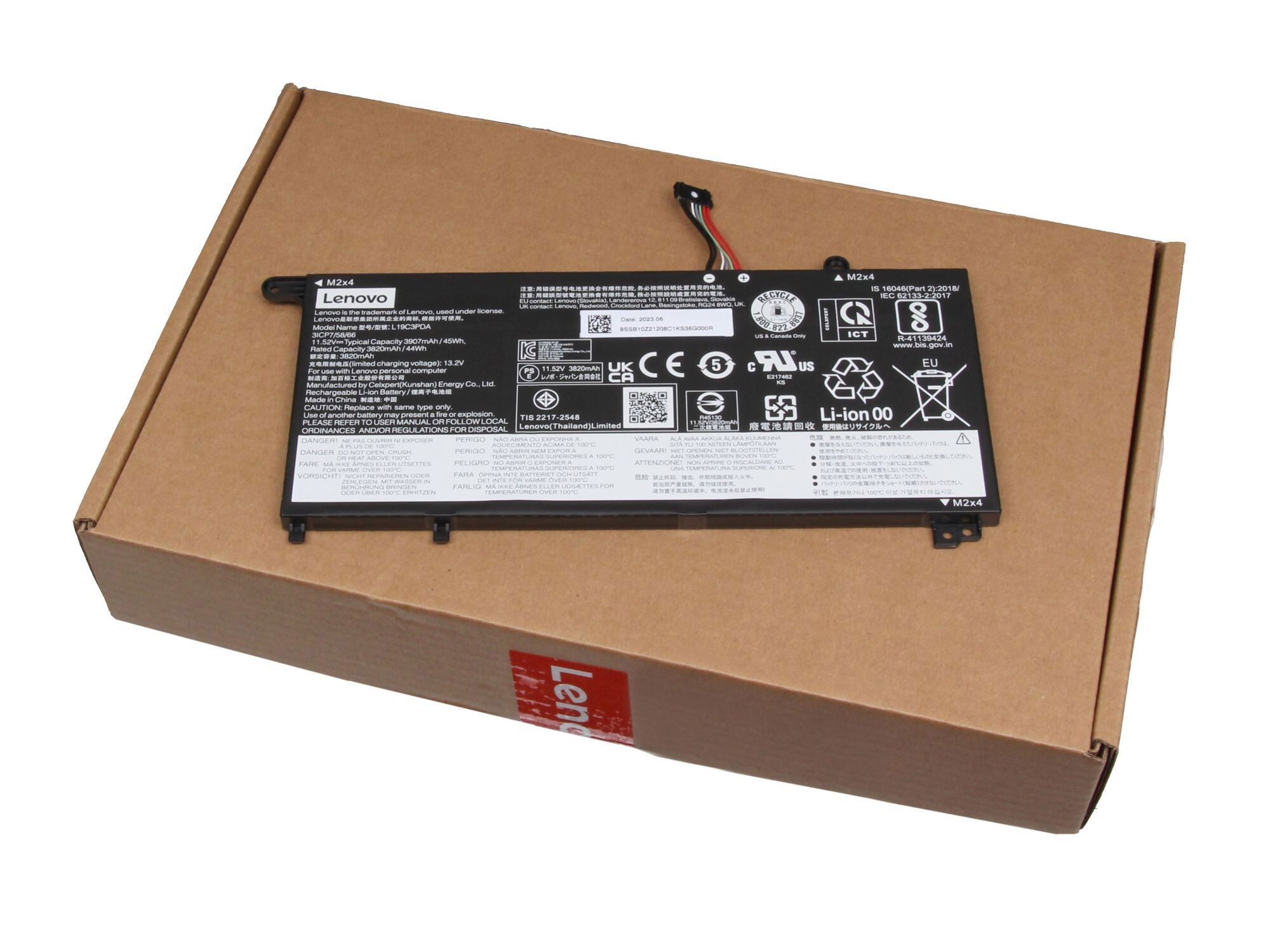 Ein Laptop-Akku auf einem Karton, mit Etiketten und Informationen.