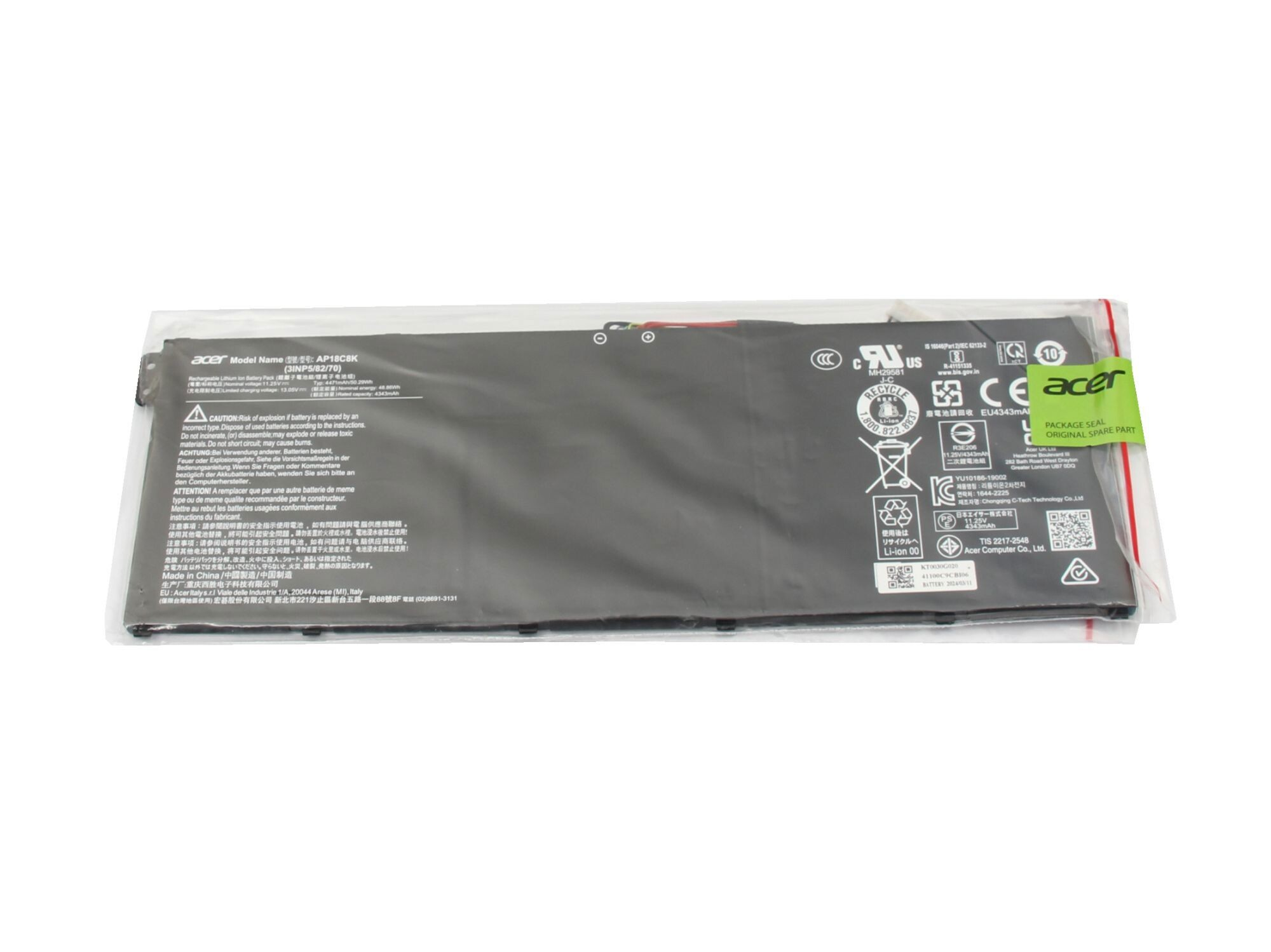 Ein Laptop-Akku in einer transparenten Plastikverpackung mit sichtbaren Etiketten und Warnhinweisen.
