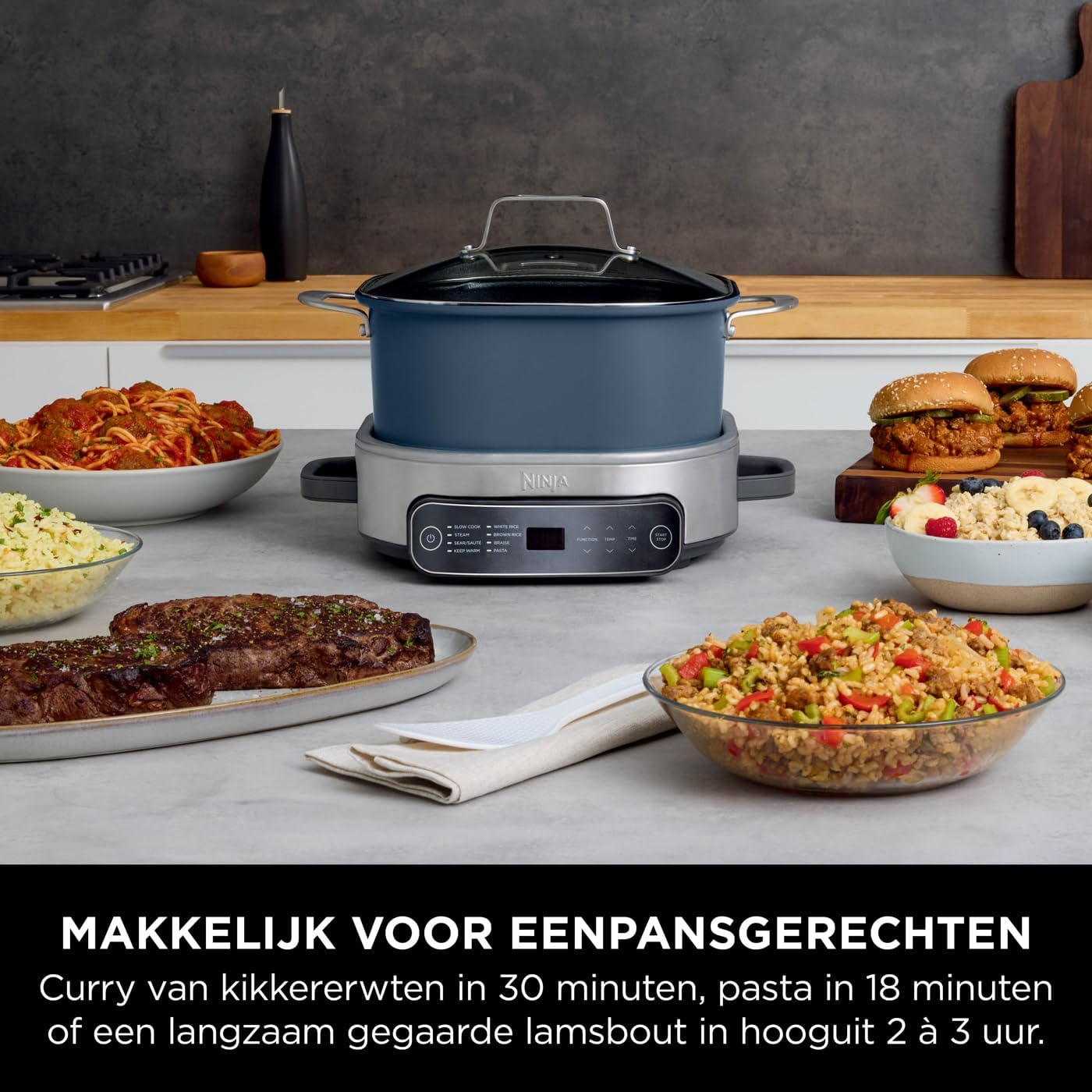A Ninja multi-cooker surrounded by dishes of food: pasta, burgers, steak, curry, and rice.