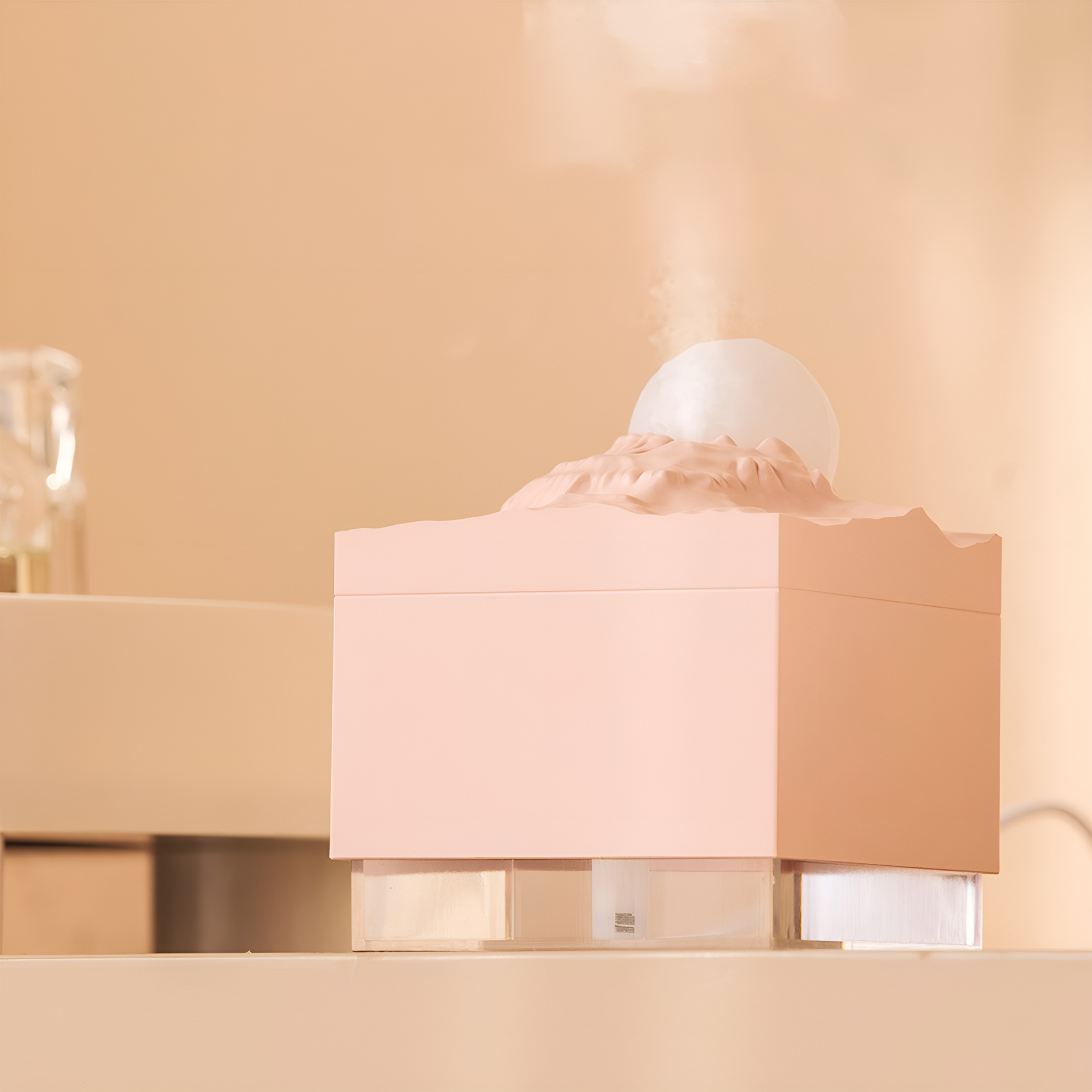 Pink-weißer Luftbefeuchter auf einem weißen Regal. Das Design hat eine bergähnliche Spitze.