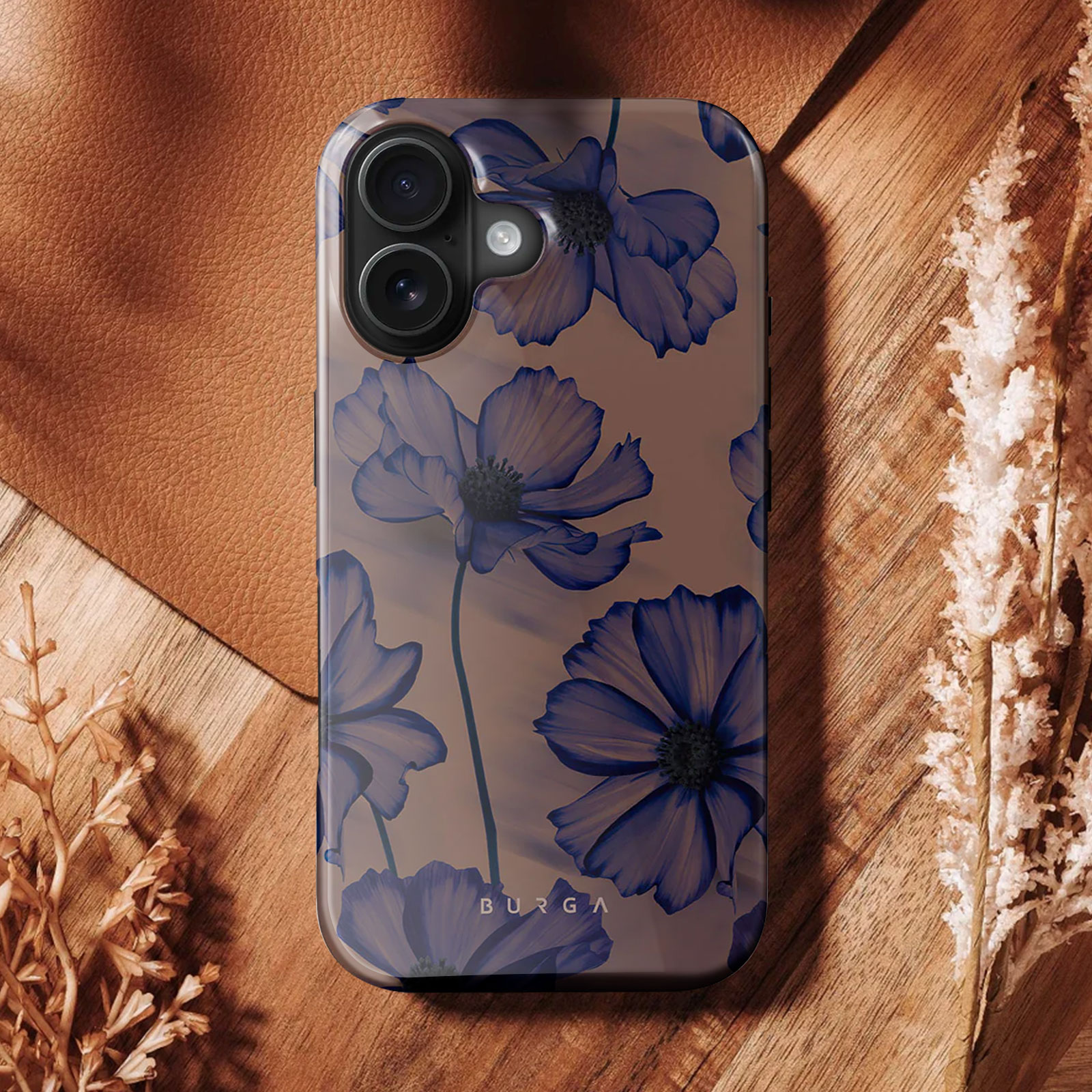 Een telefoonhoesje met blauw bloemmotief, geplaatst op een houten oppervlak.