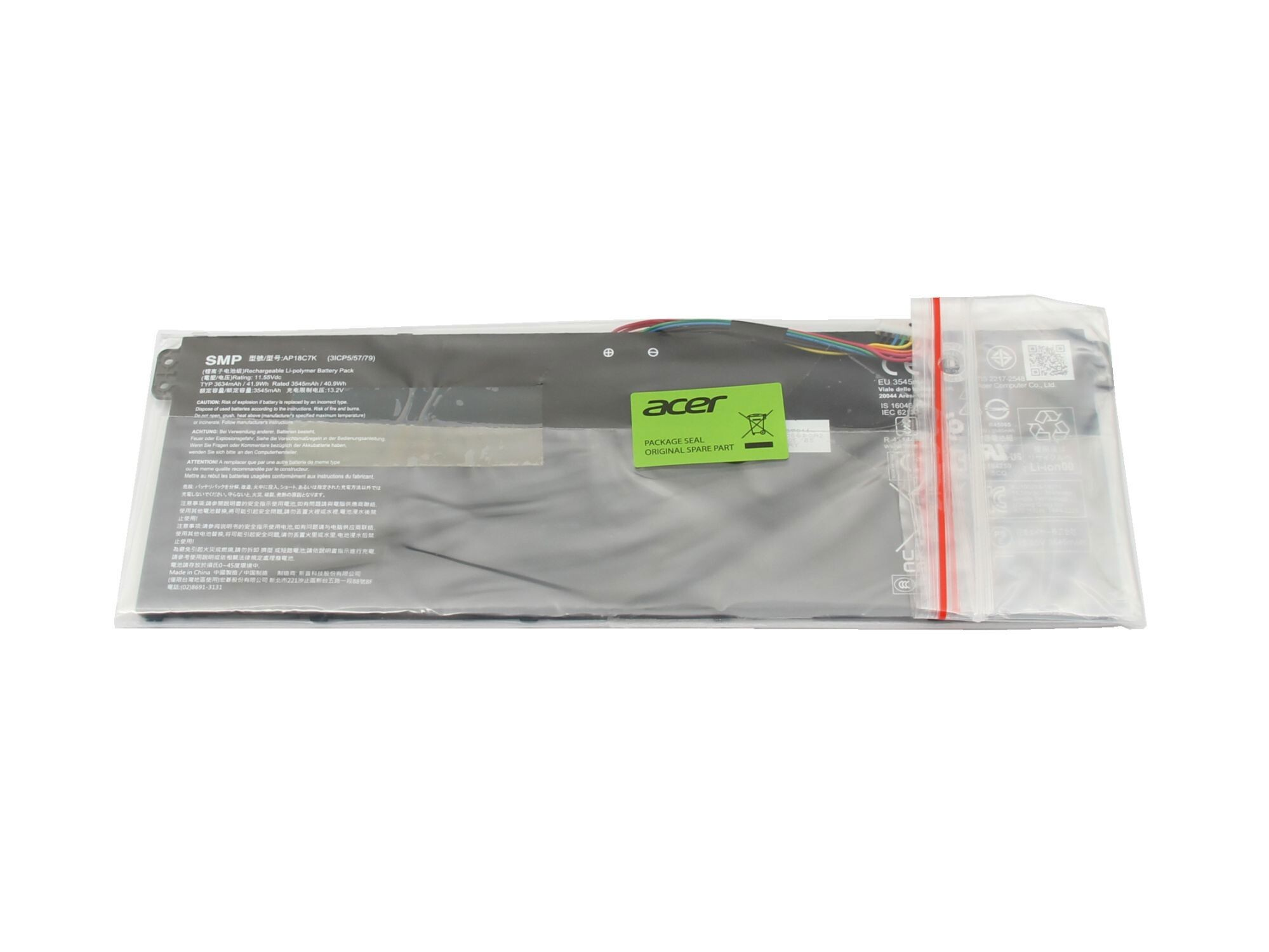 Laptop-Akku in einer Plastiktüte, mit einem grünen Aufkleber.