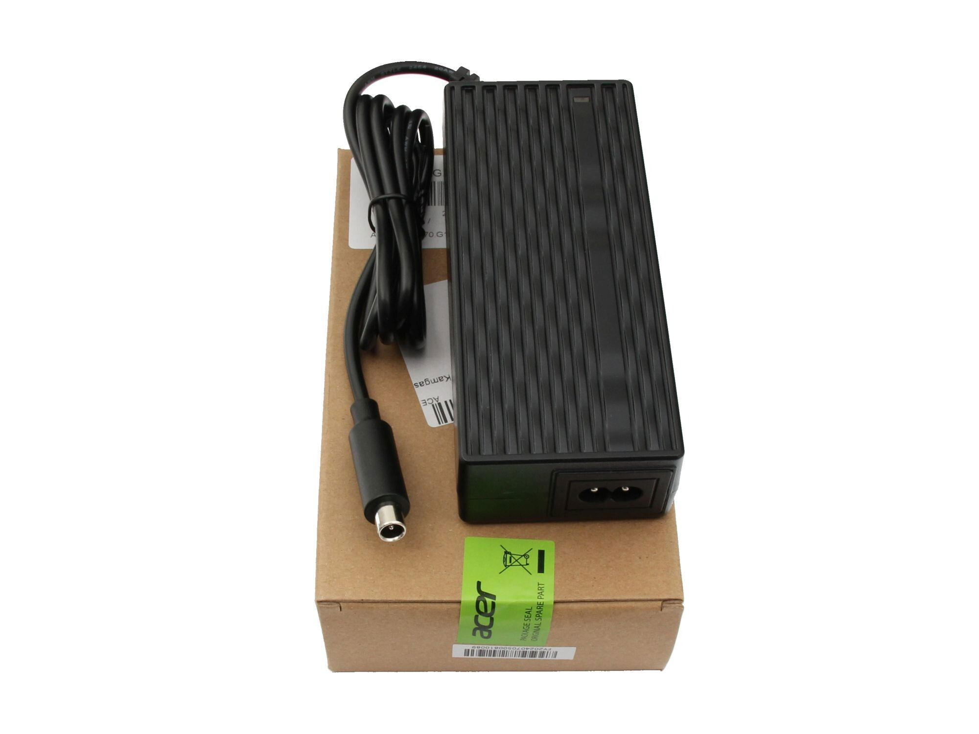 Schwarzes Laptop-Ladegerät mit Kabel auf Karton mit grünem Aufkleber, auf Weiß.