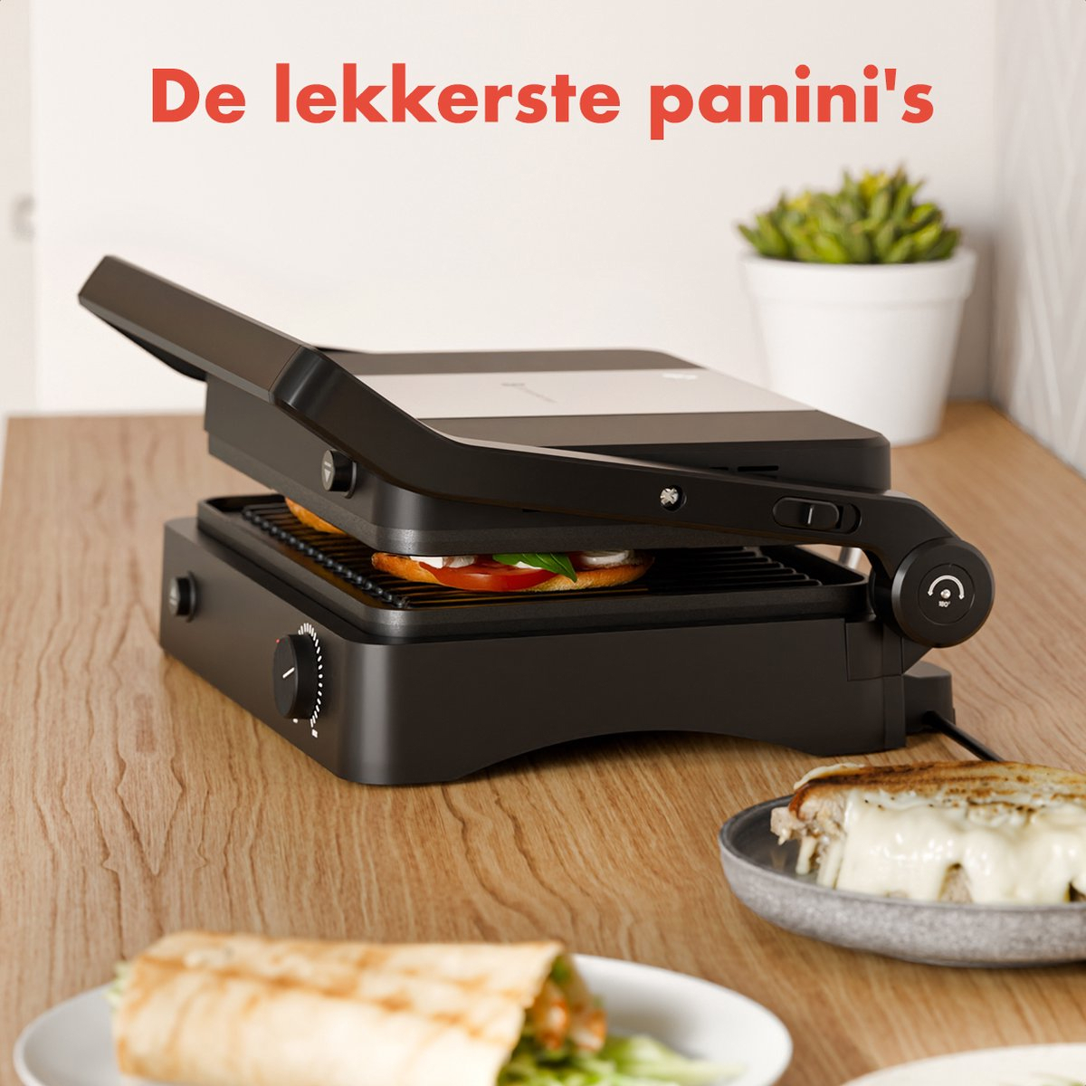 A black panini press with a panini being cooked. A sandwich and a plant are in the background.