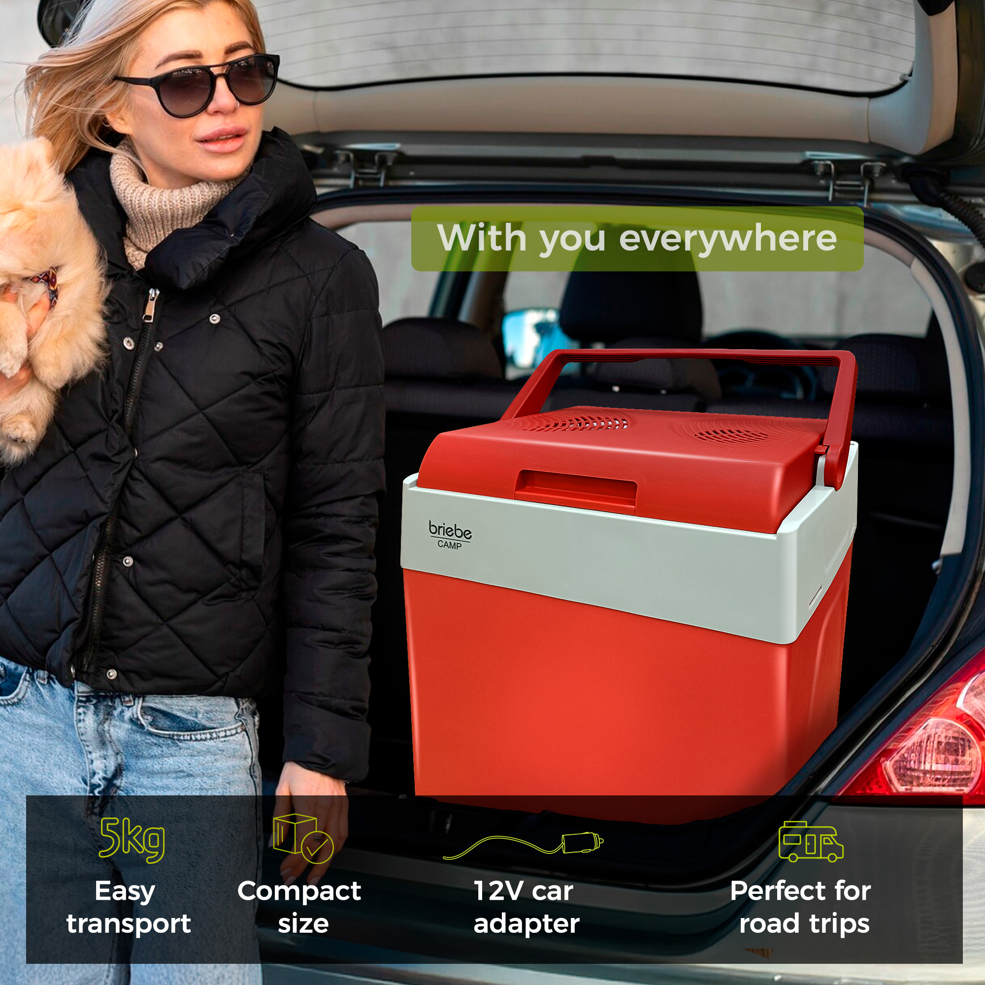 Eine Frau mit Sonnenbrille hält einen kleinen Hund. Ein roter Kühler befindet sich im Kofferraum des Autos mit Text. Die Szene ist im Freien.