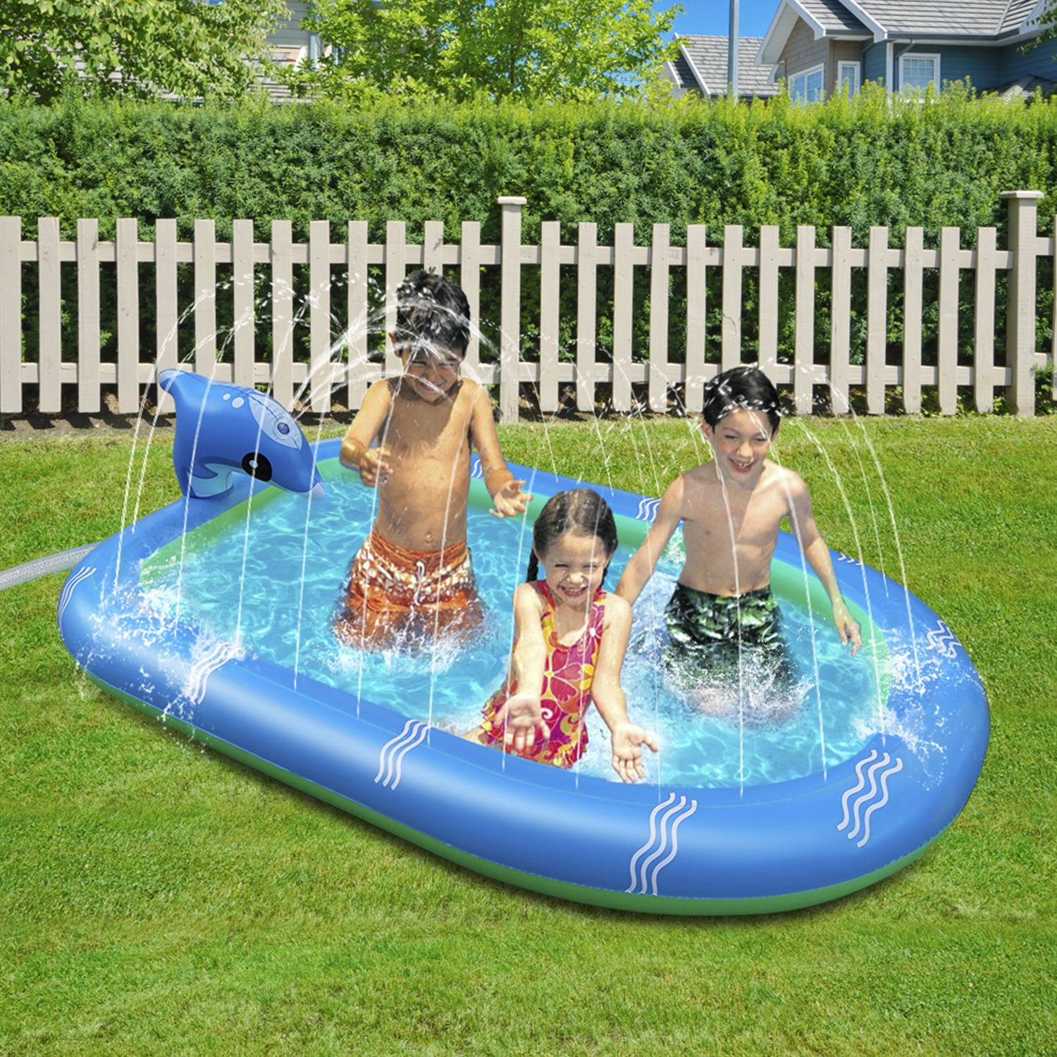 Bambini che giocano in una piscina a forma di delfino. Spruzzi d'acqua, recinzione bianca ed erba verde.